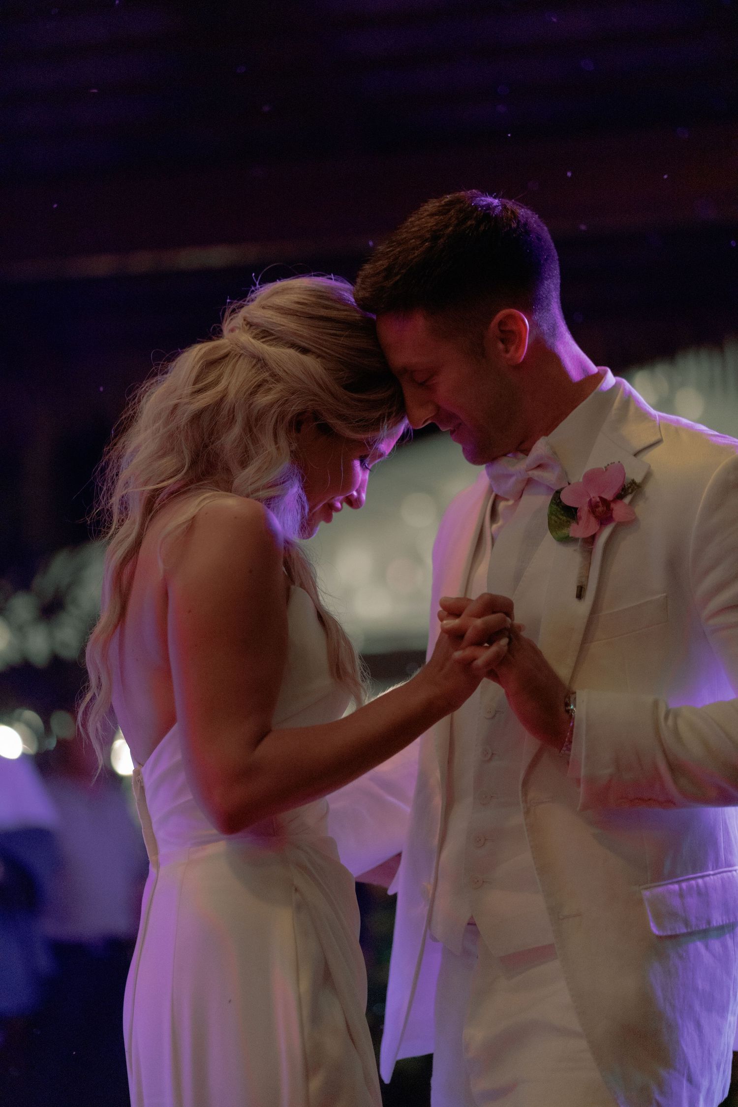 Couple sharing intimate slow dance moment at wedding reception.