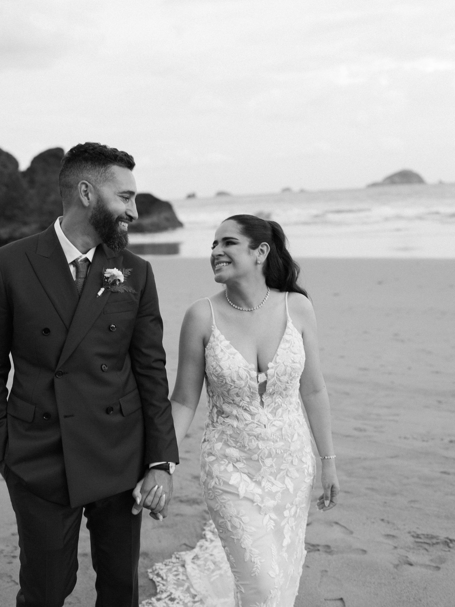 Joyful couple sharing laughter during their beach wedding photoshoot.