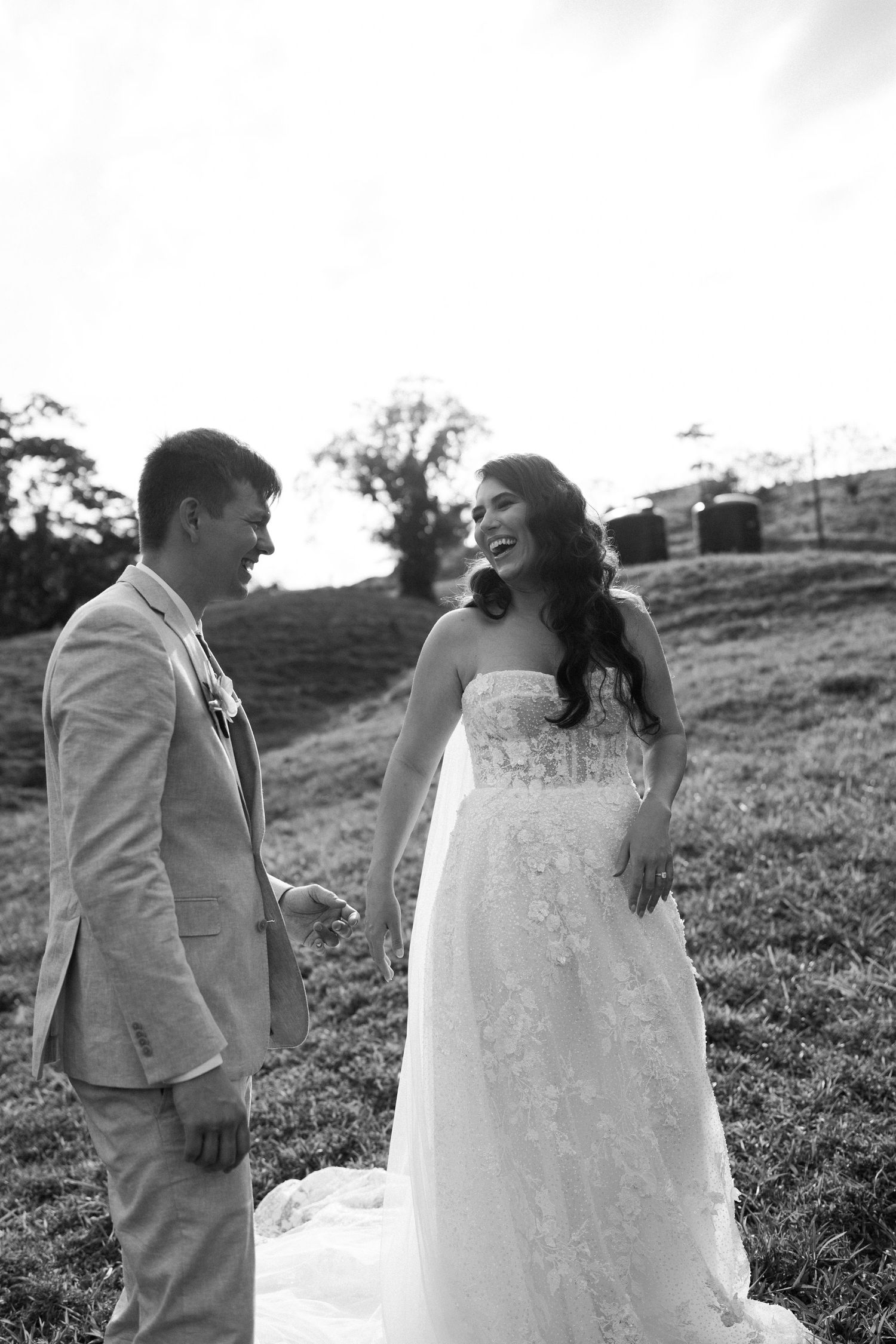 Black and white wedding portraits captured on a grassy hillside.