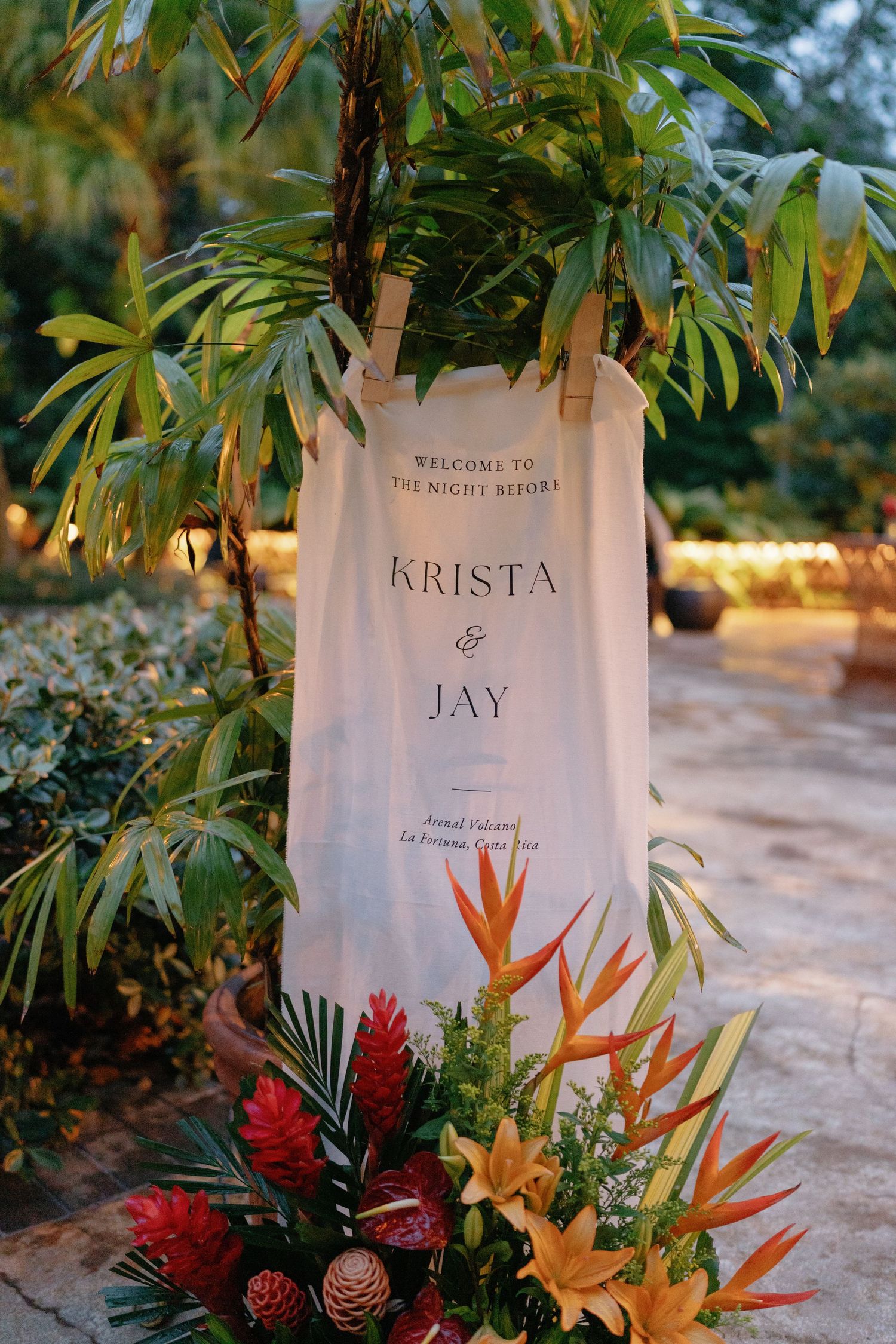 Tropical wedding welcome sign with birds of paradise flowers and bamboo decor.
