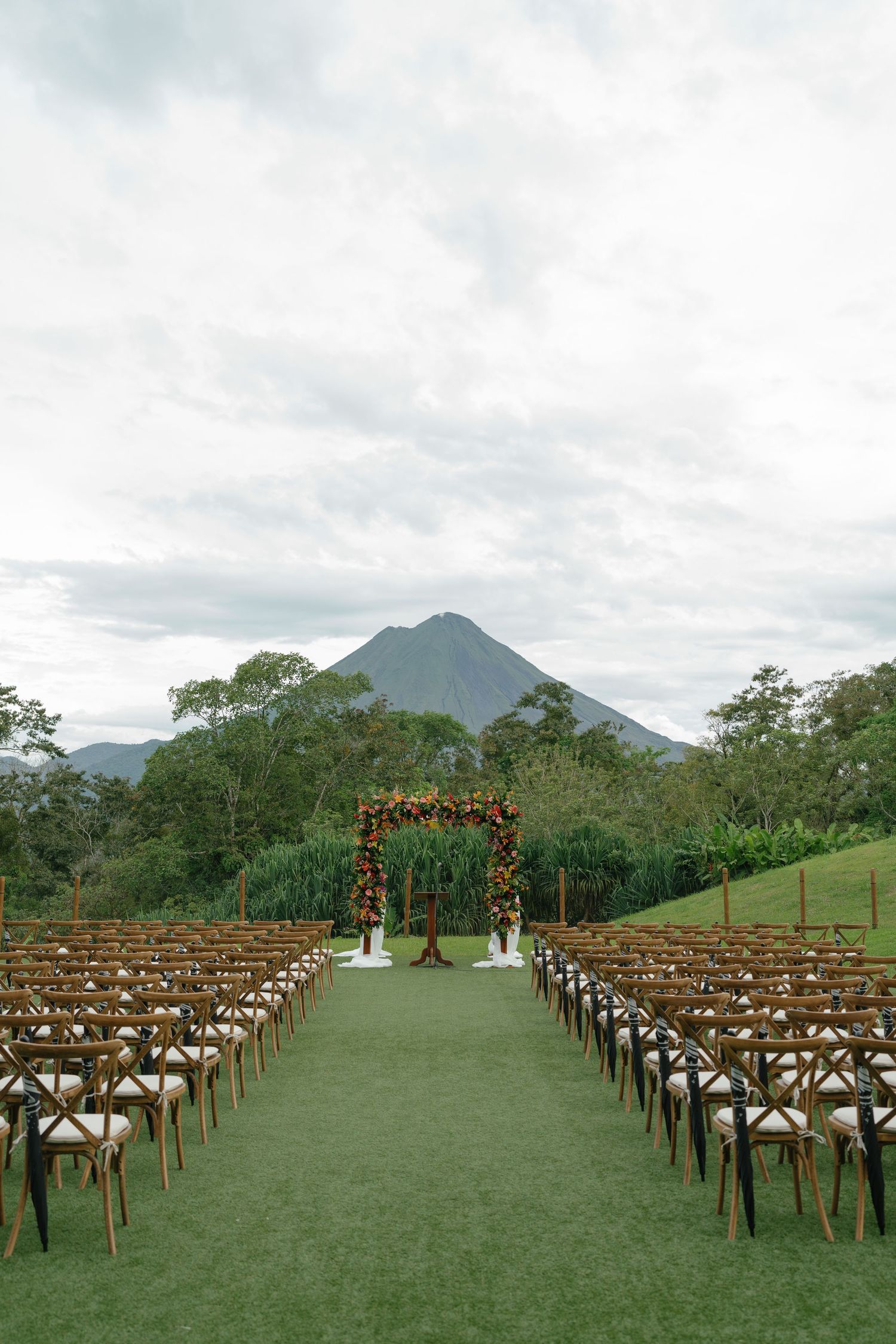 Outdoor wedding ceremony setup with wooden chairs facing mountain vista.