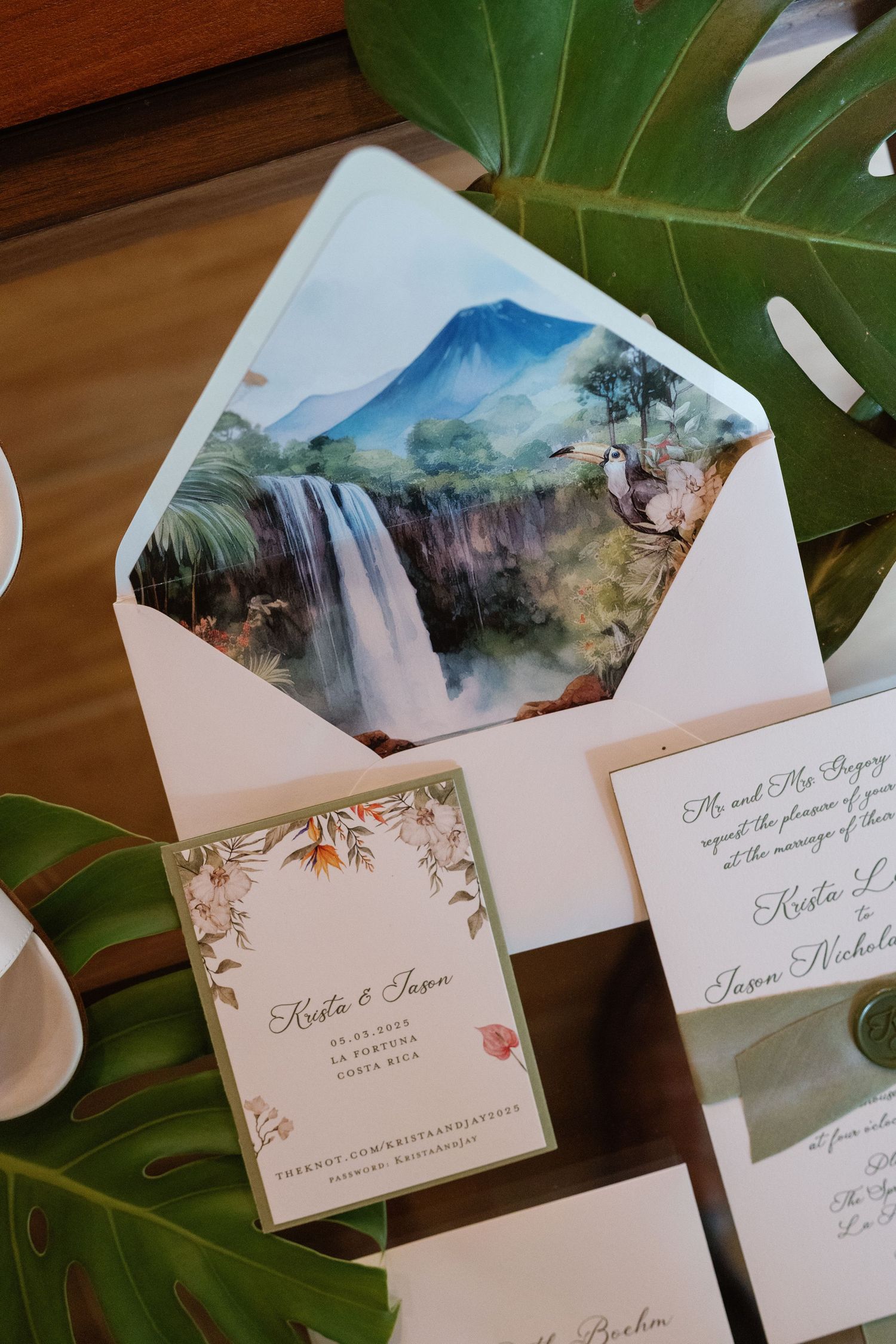 Wedding invitations with watercolor landscape designs on tropical leaves.