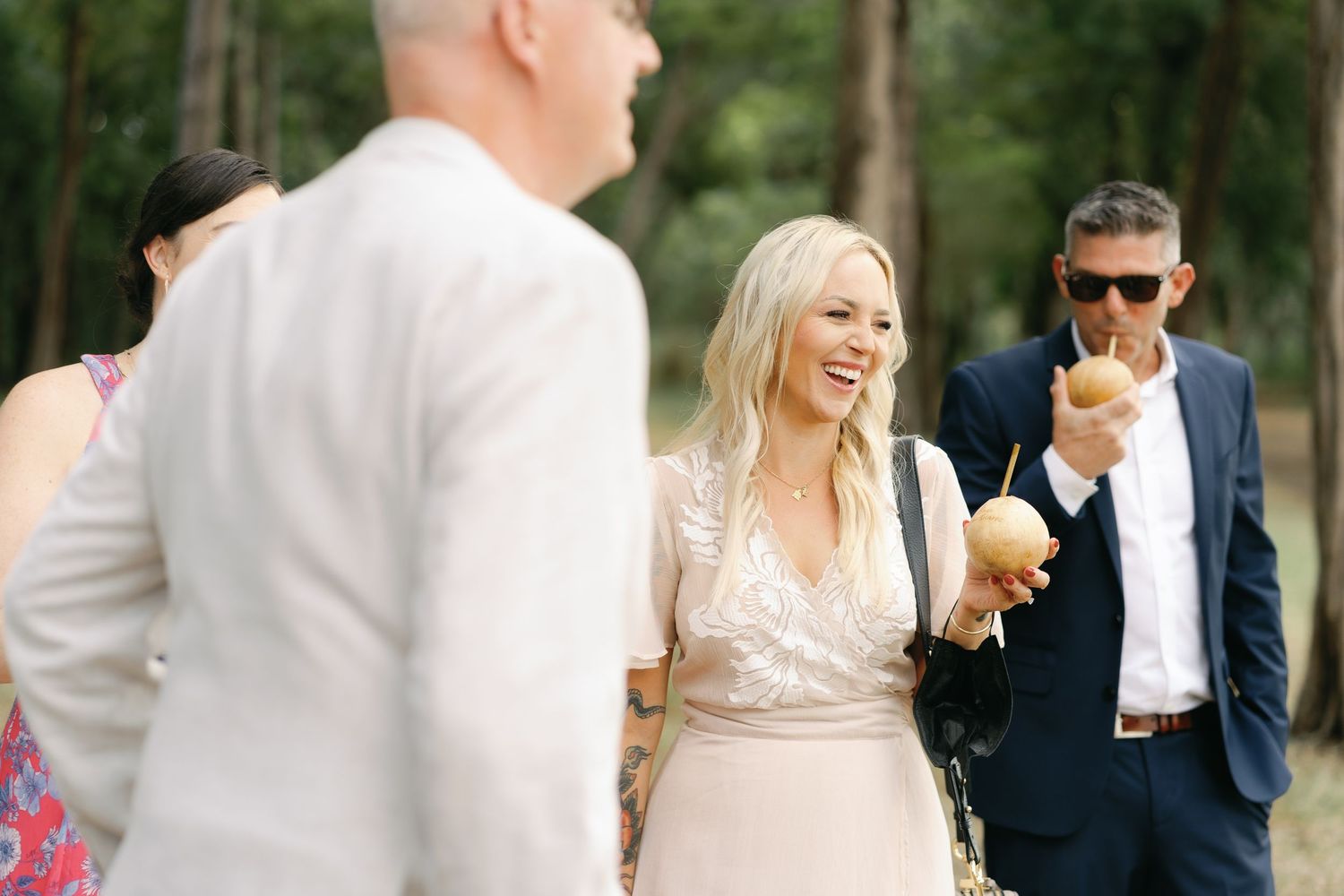 Wedding guests walking and mingling outdoors during a garden reception.