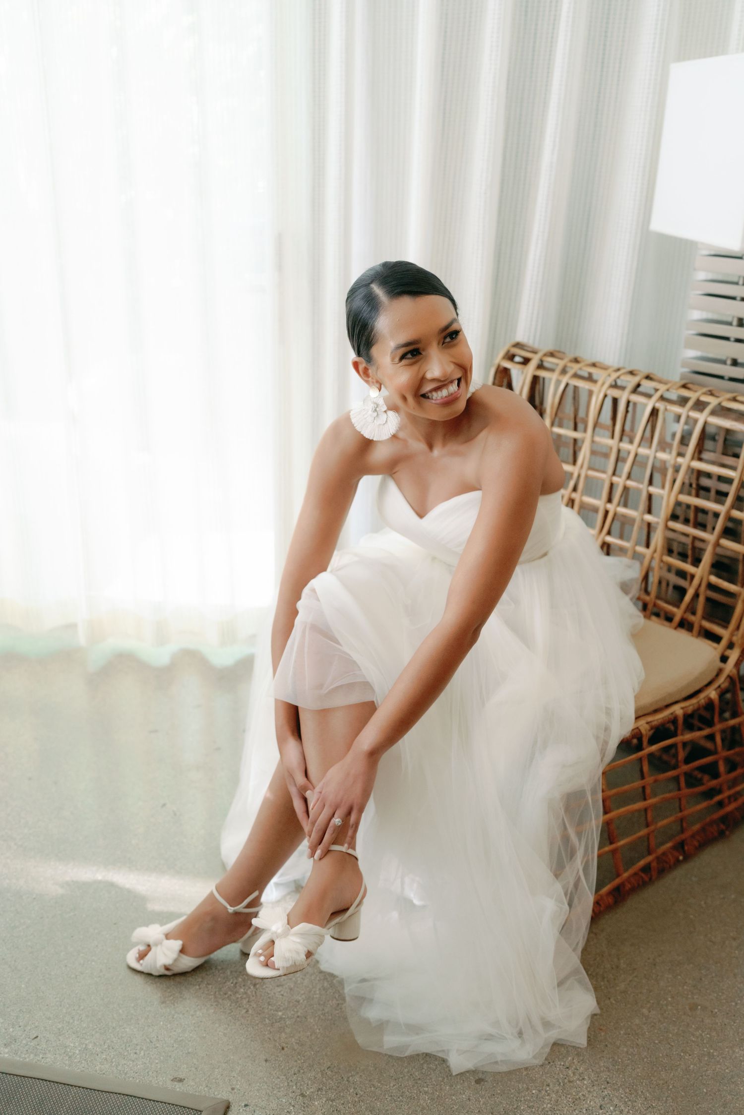 Wedding preparation scene showing white bridal shoes and flowing dress details.