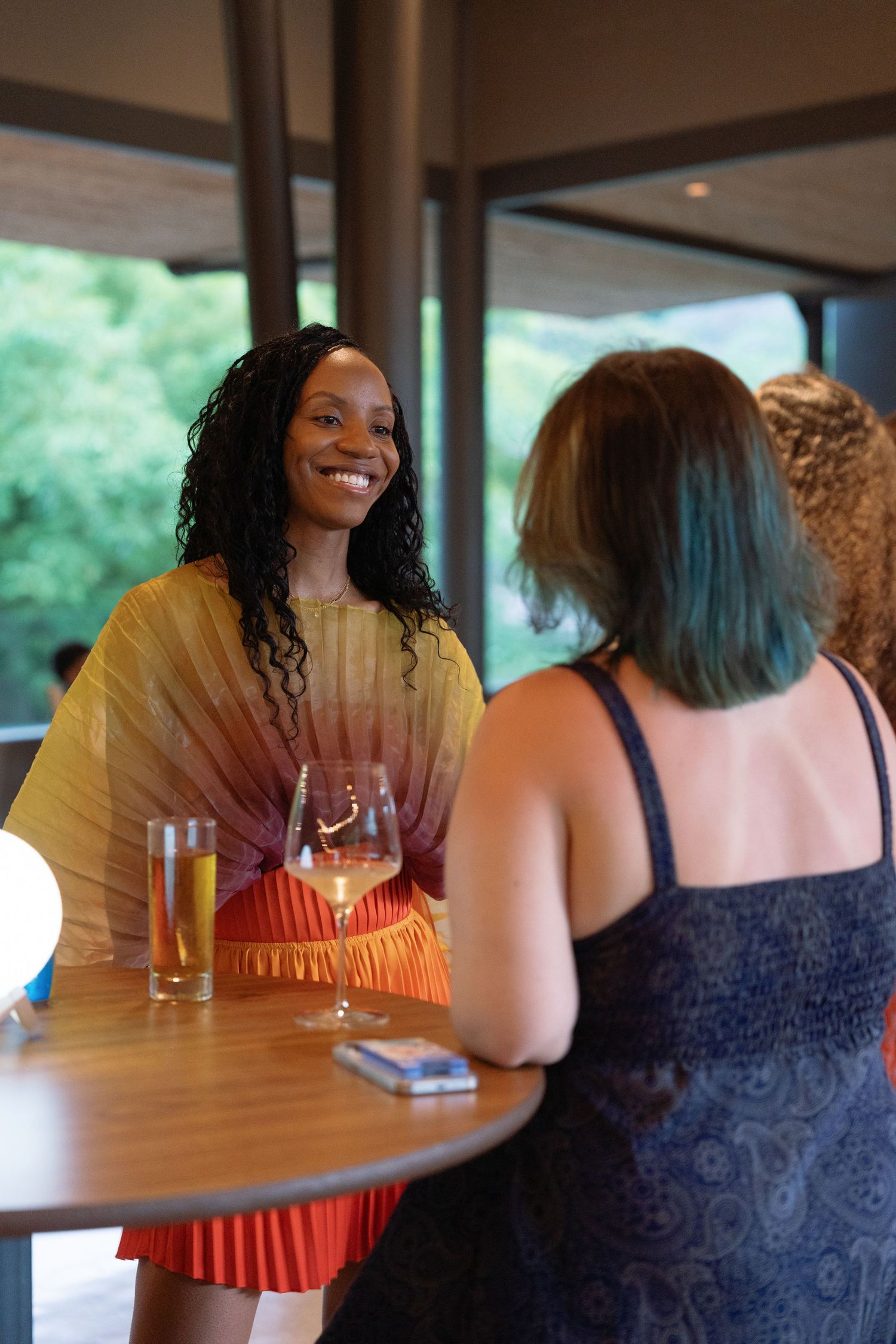 Friends enjoying drinks and conversation at a restaurant table.