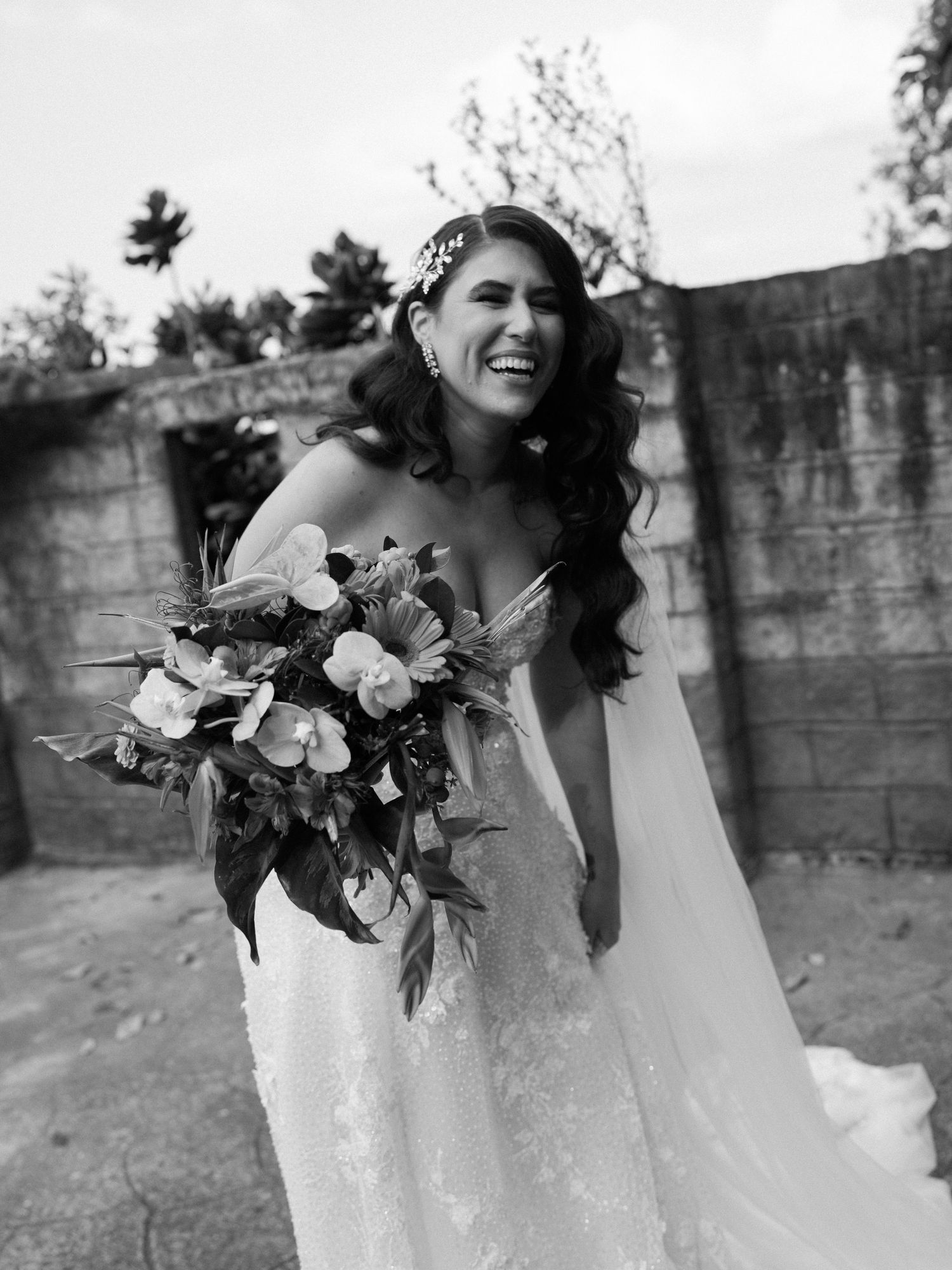 Black and white photo of a bride holding a vibrant floral bouquet.