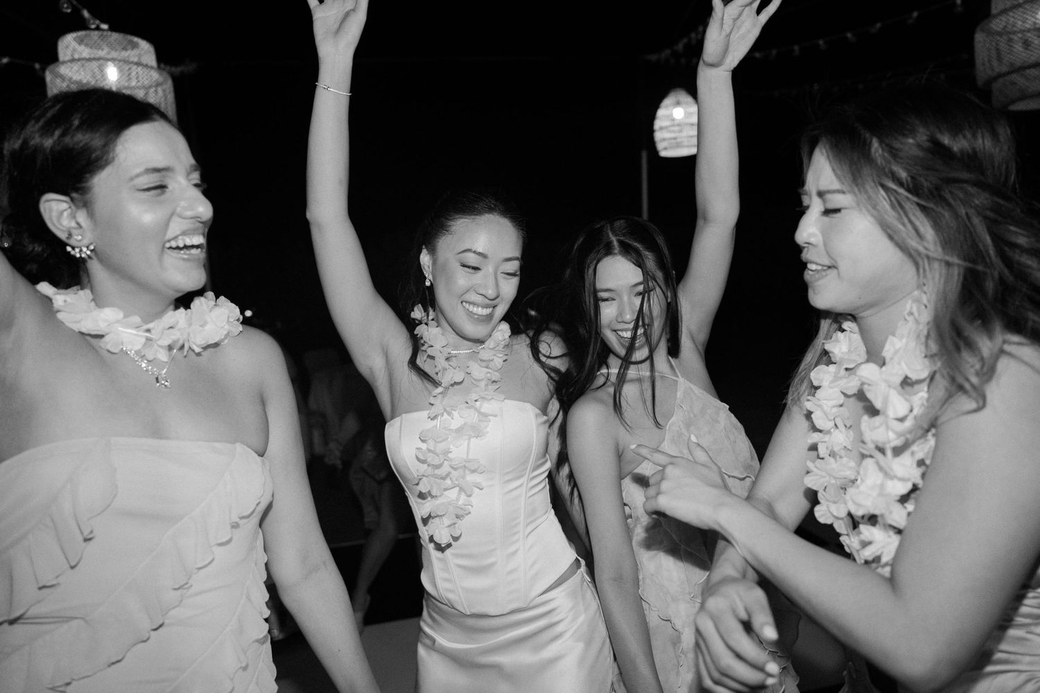 Wedding guests dancing and celebrating at a nighttime outdoor reception.