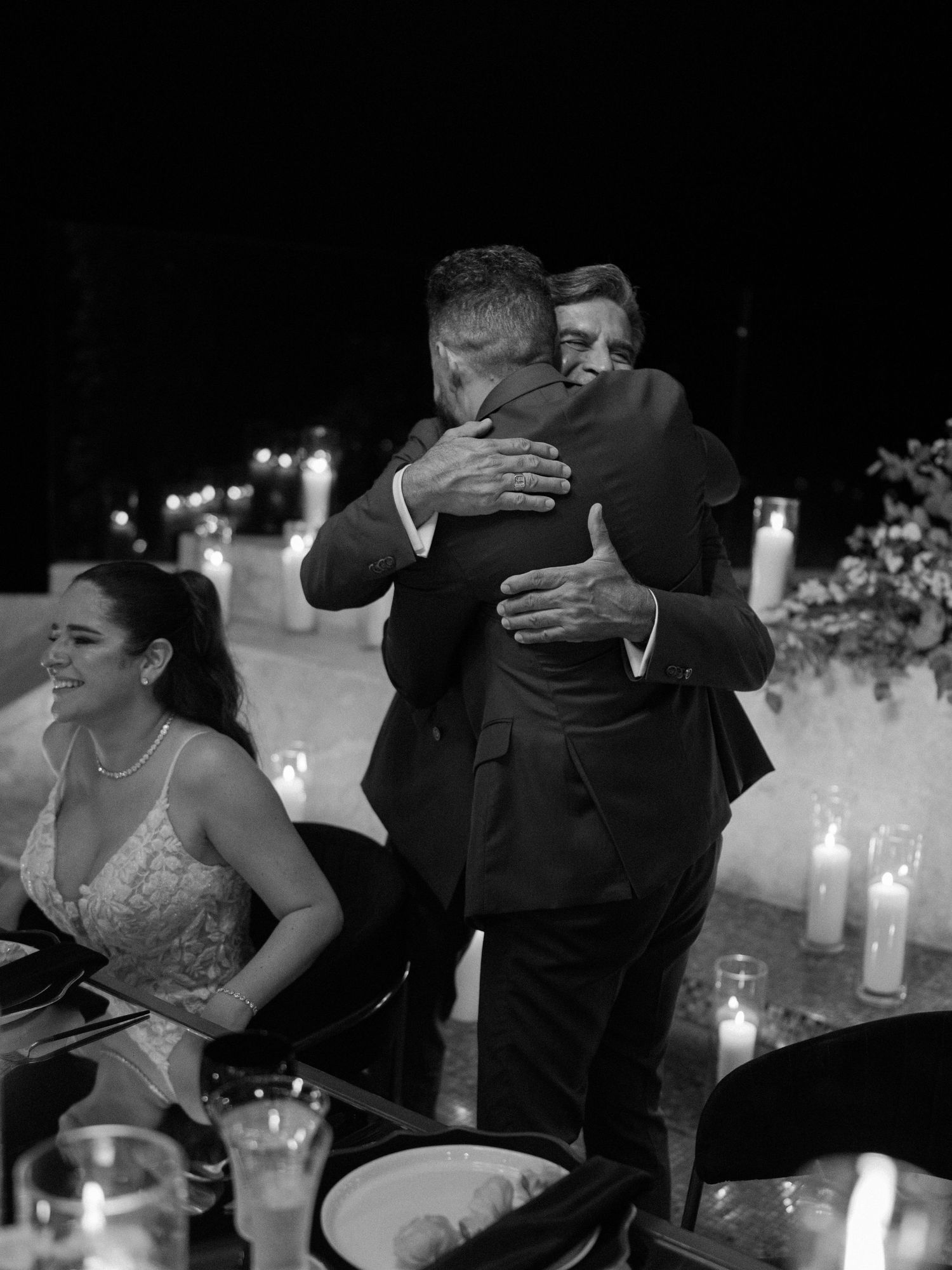 Intimate black and white wedding reception moment captured by candlelight.