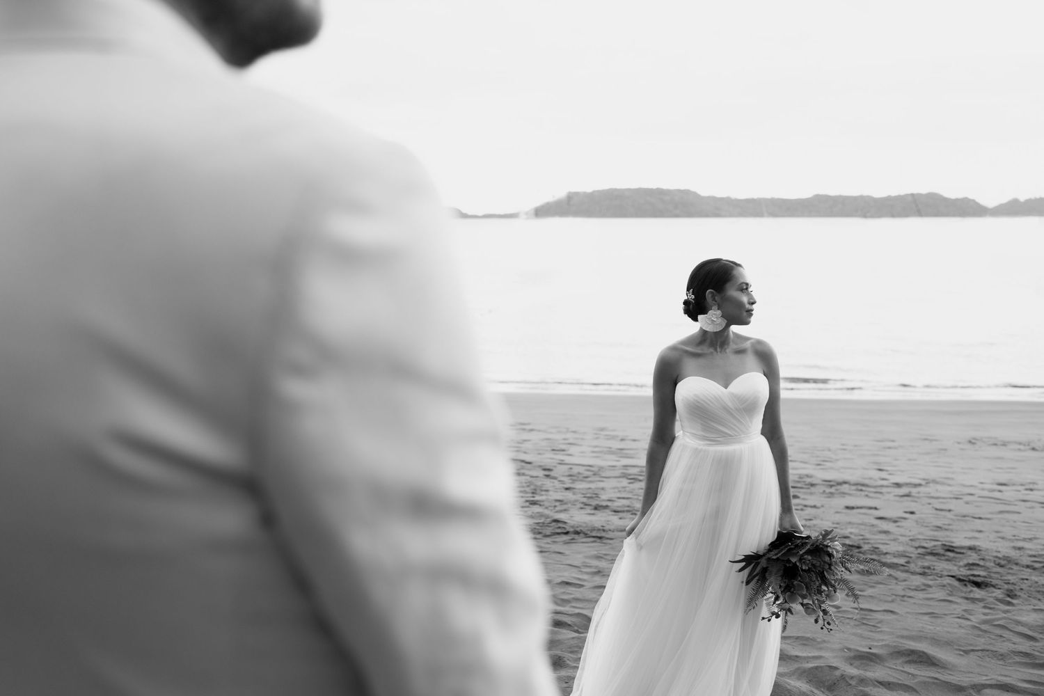 Black and white beach wedding photos showing silhouettes against an ocean backdrop.