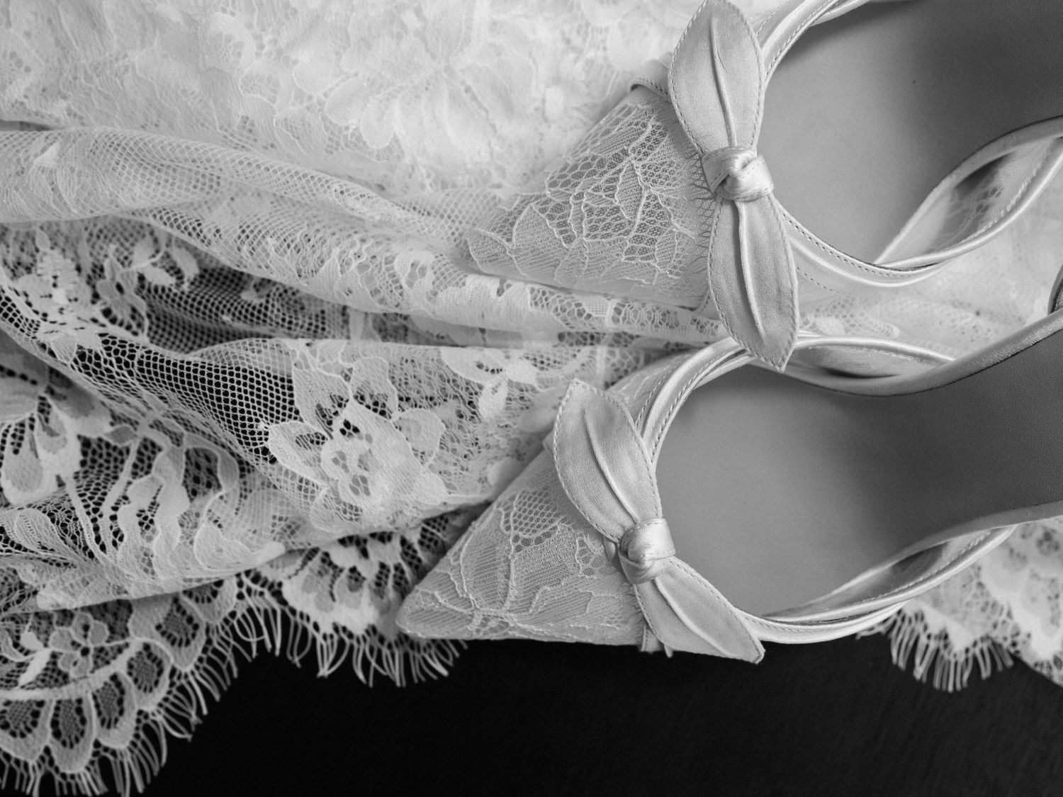 Delicate white lace trim and ribbon details on fabric create an elegant textural pattern.