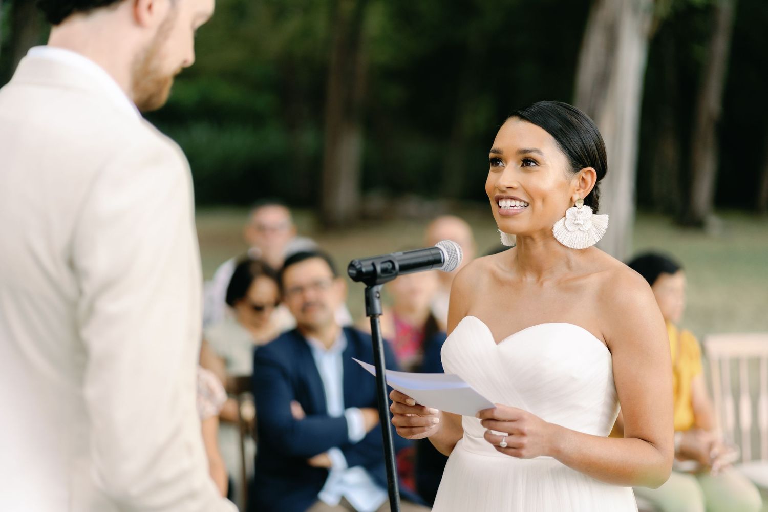 Outdoor wedding ceremony with couple exchanging vows under natural lighting.