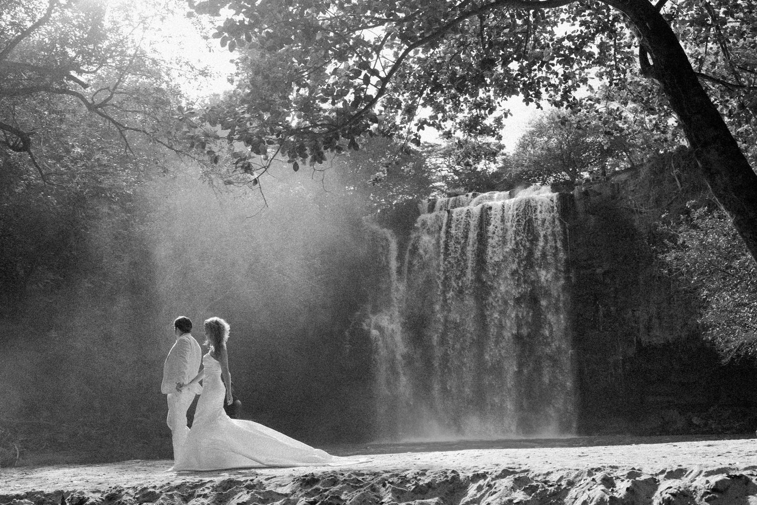 Ethereal black and white wedding photos captured by a cascading waterfall.
