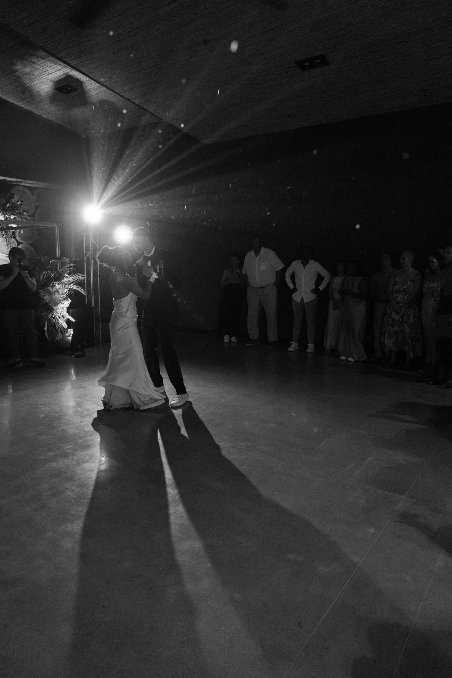 Silhouettes of couples dancing on a dark dance floor with dramatic lighting.