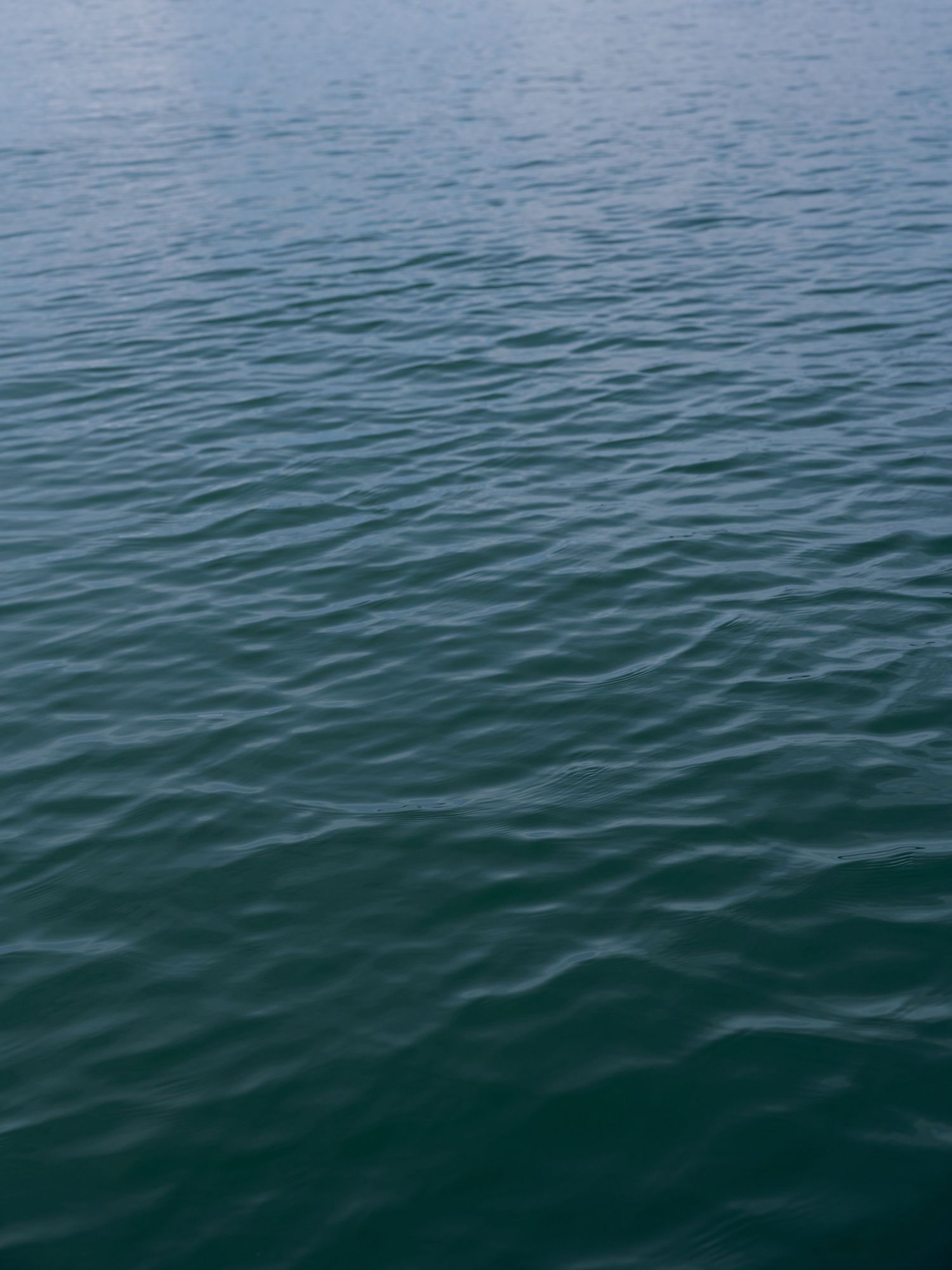 Calm blue-green ocean water with gentle ripples creating a serene surface pattern.