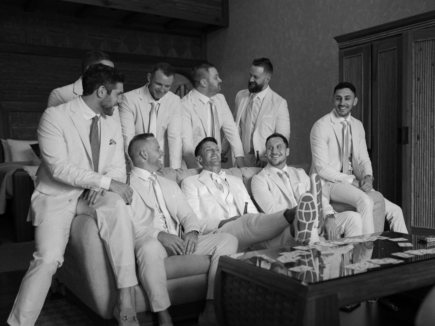 Group of people in white attire seated at a long table during a formal event.