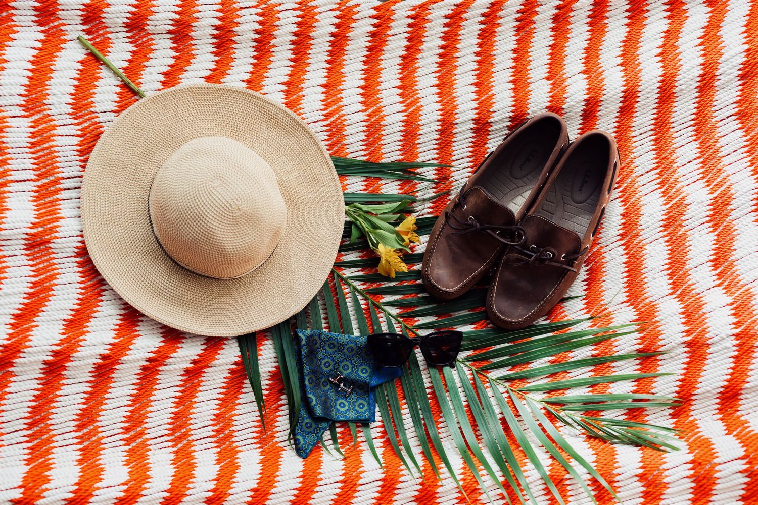 Red and white striped pattern with beach accessories and palm leaves.