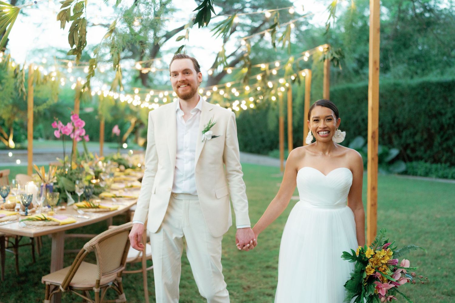 Outdoor wedding reception setup with string lights and wooden posts creating an intimate atmosphere.