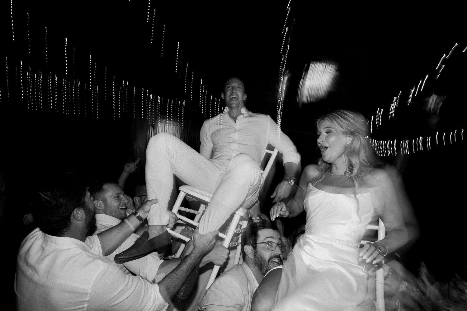Black and white photos capture joyful dancing and celebration at a wedding reception.