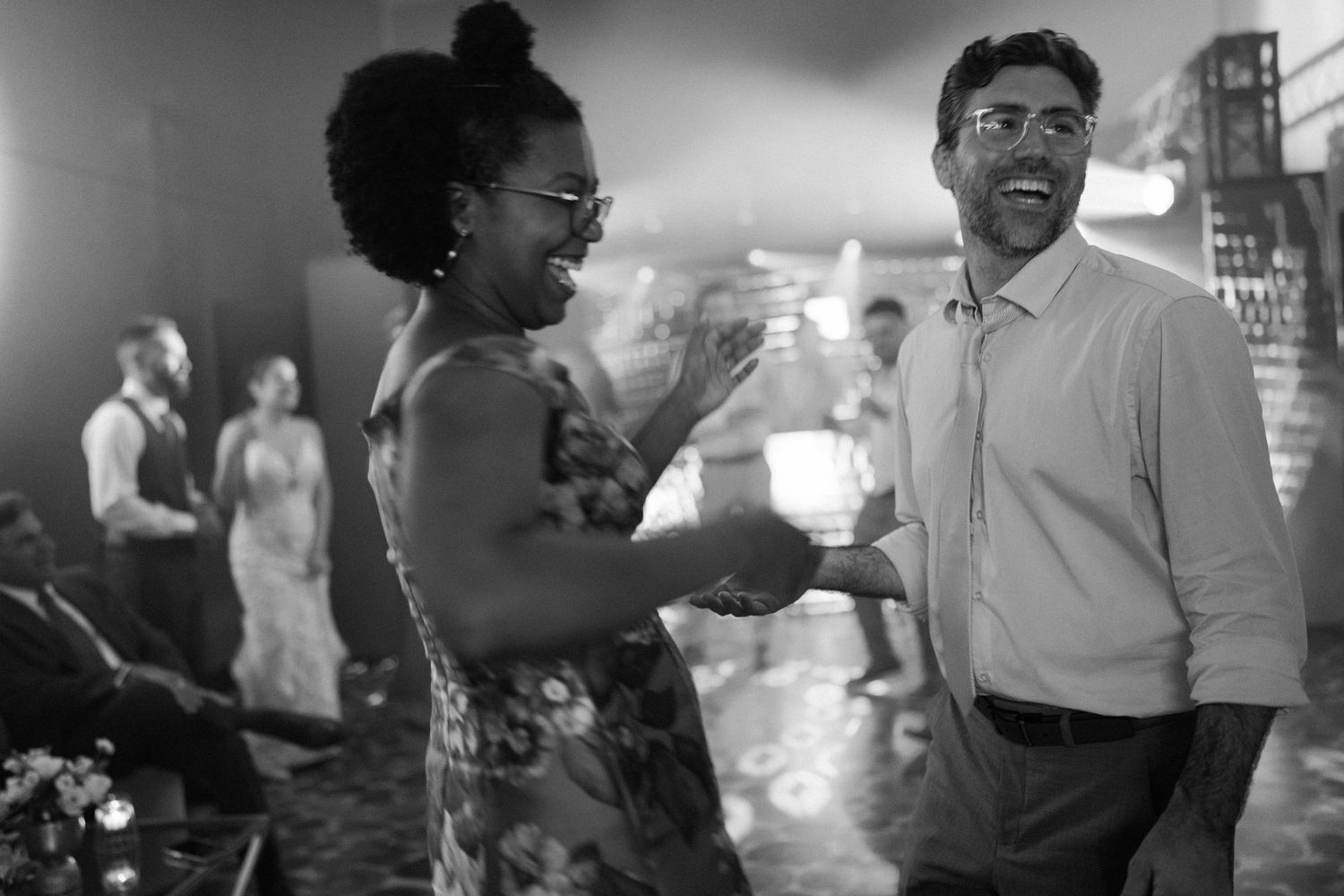 A candid black and white photo capturing joyful moments at a social gathering.