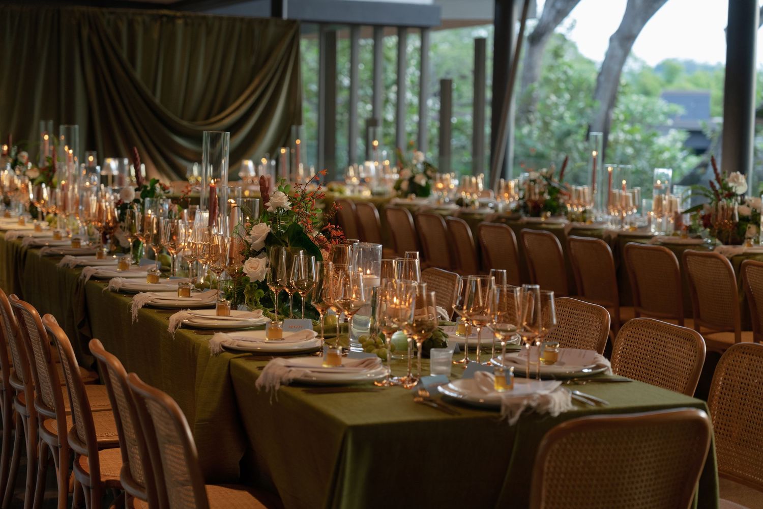 Elegant wedding reception hall with long tables set for dining and decorative centerpieces.