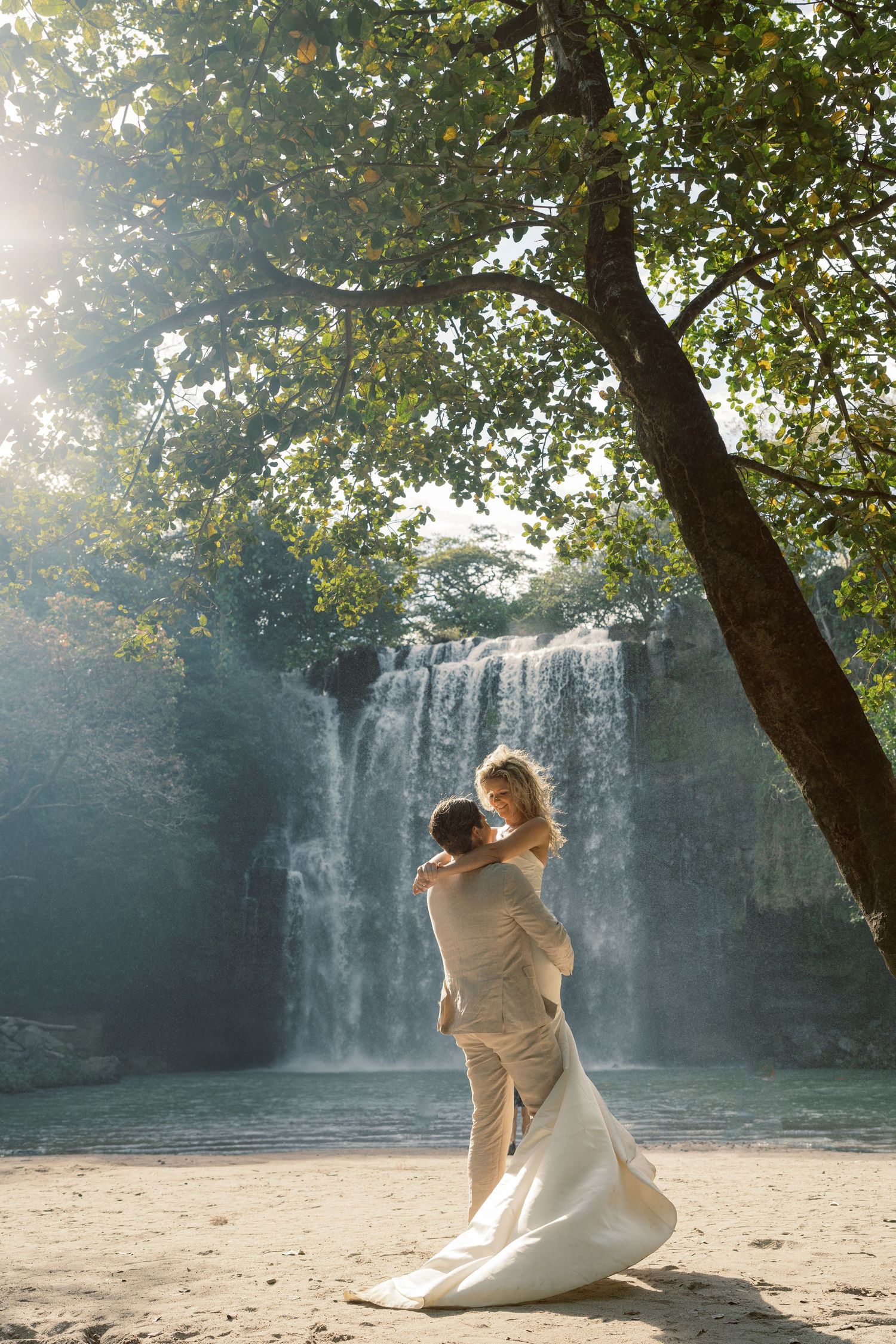 Wedding photography session near a misty waterfall with natural lighting.
