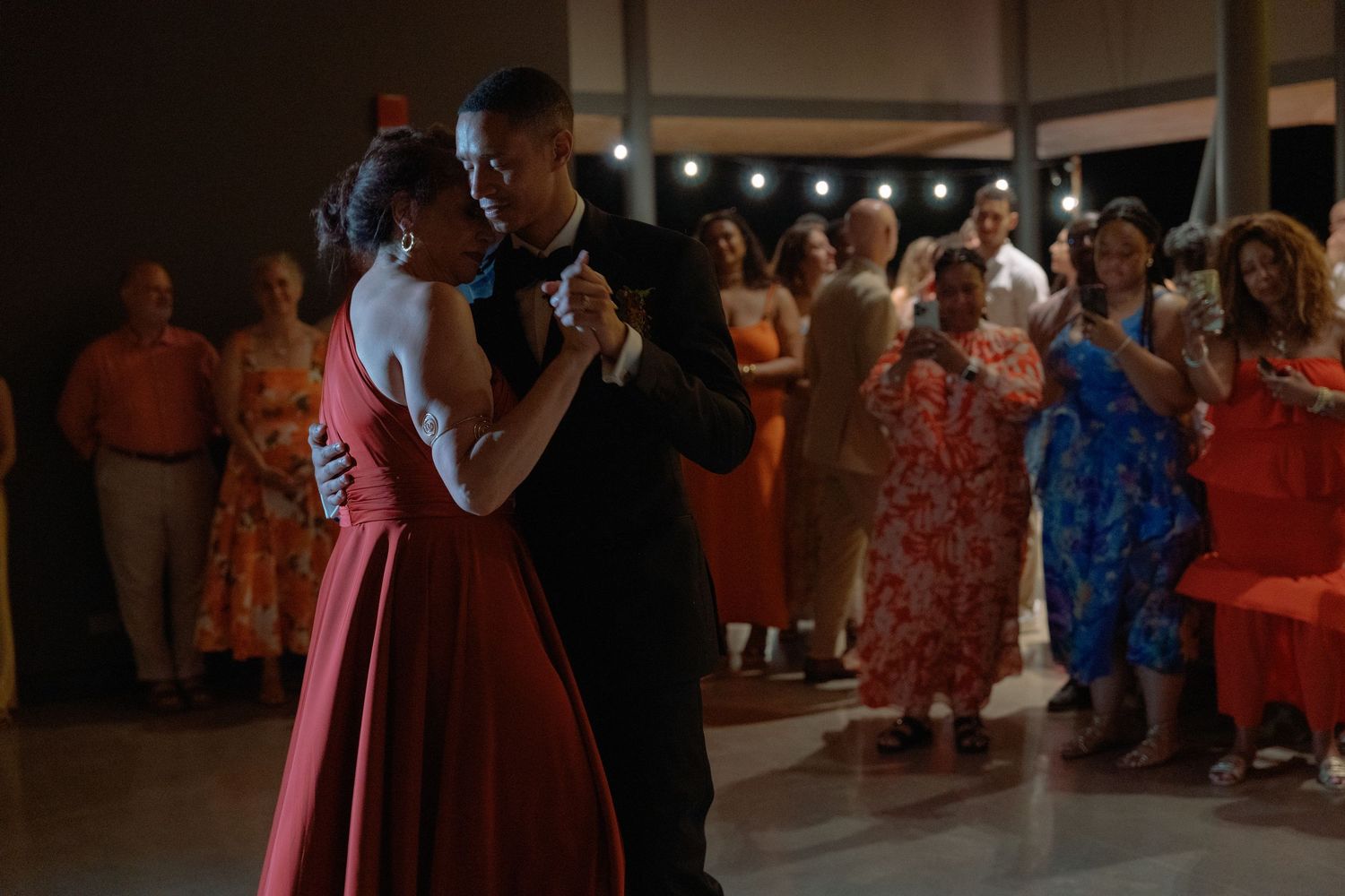 Wedding reception dance floor with guests celebrating in colorful attire.