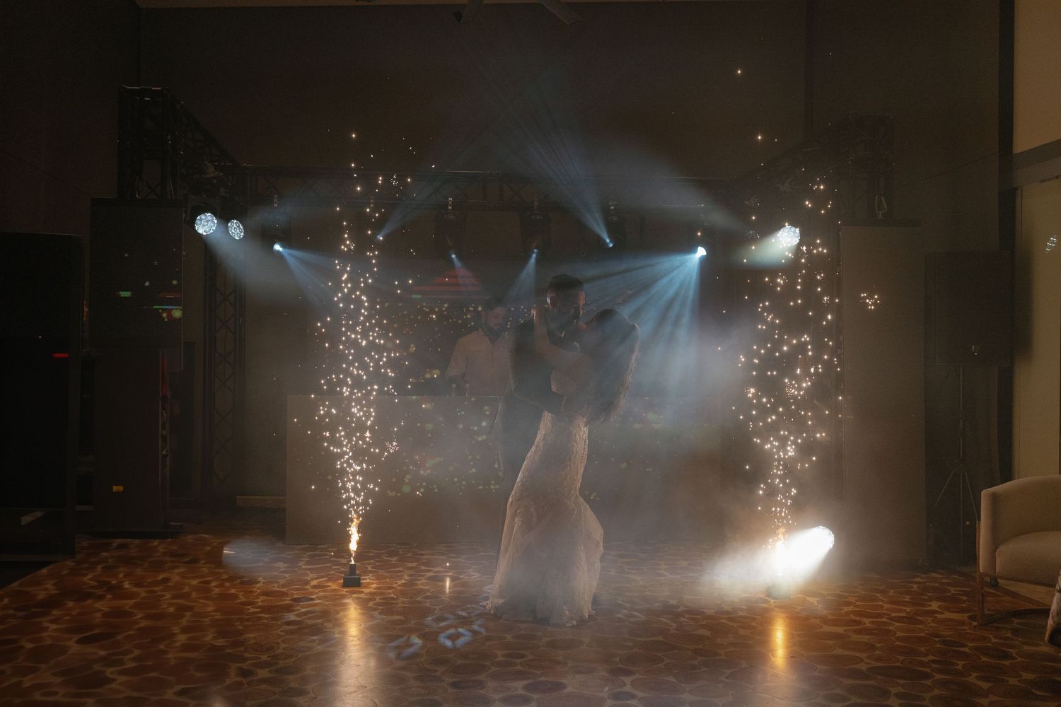 Indoor celebration with sparklers creating dramatic light effects in a dark room.