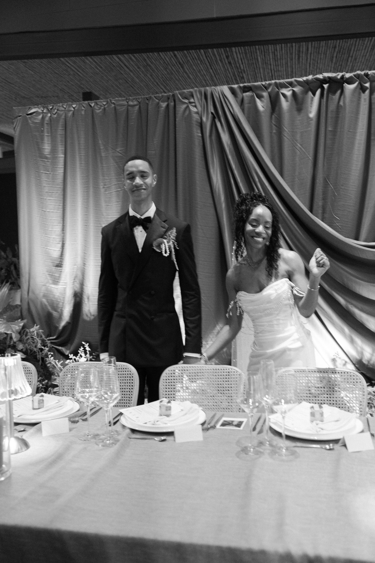 Formal wedding reception table setting with elegant place settings and glassware.