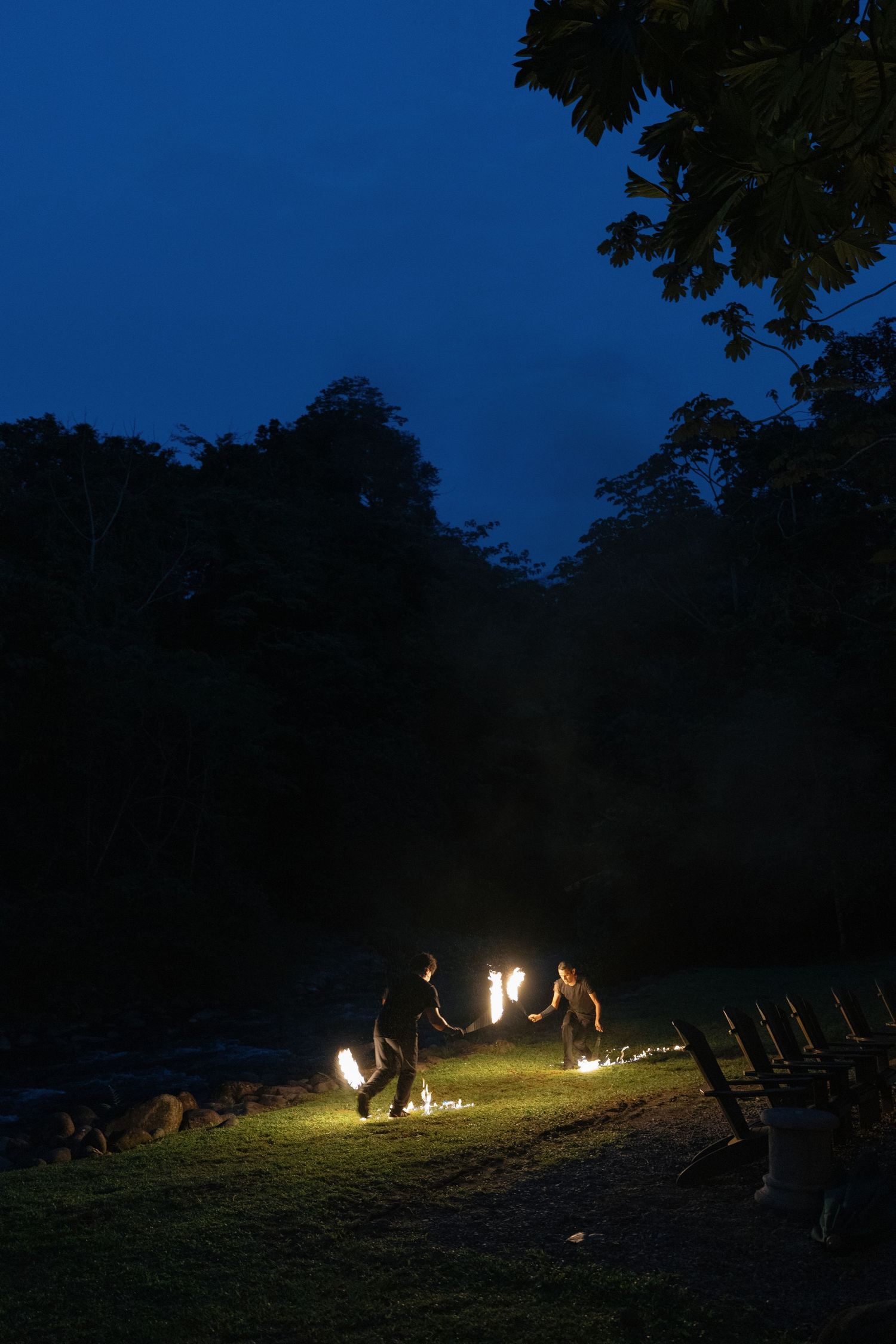 Campfire gathering under a dark blue night sky with chairs arranged in a circle.