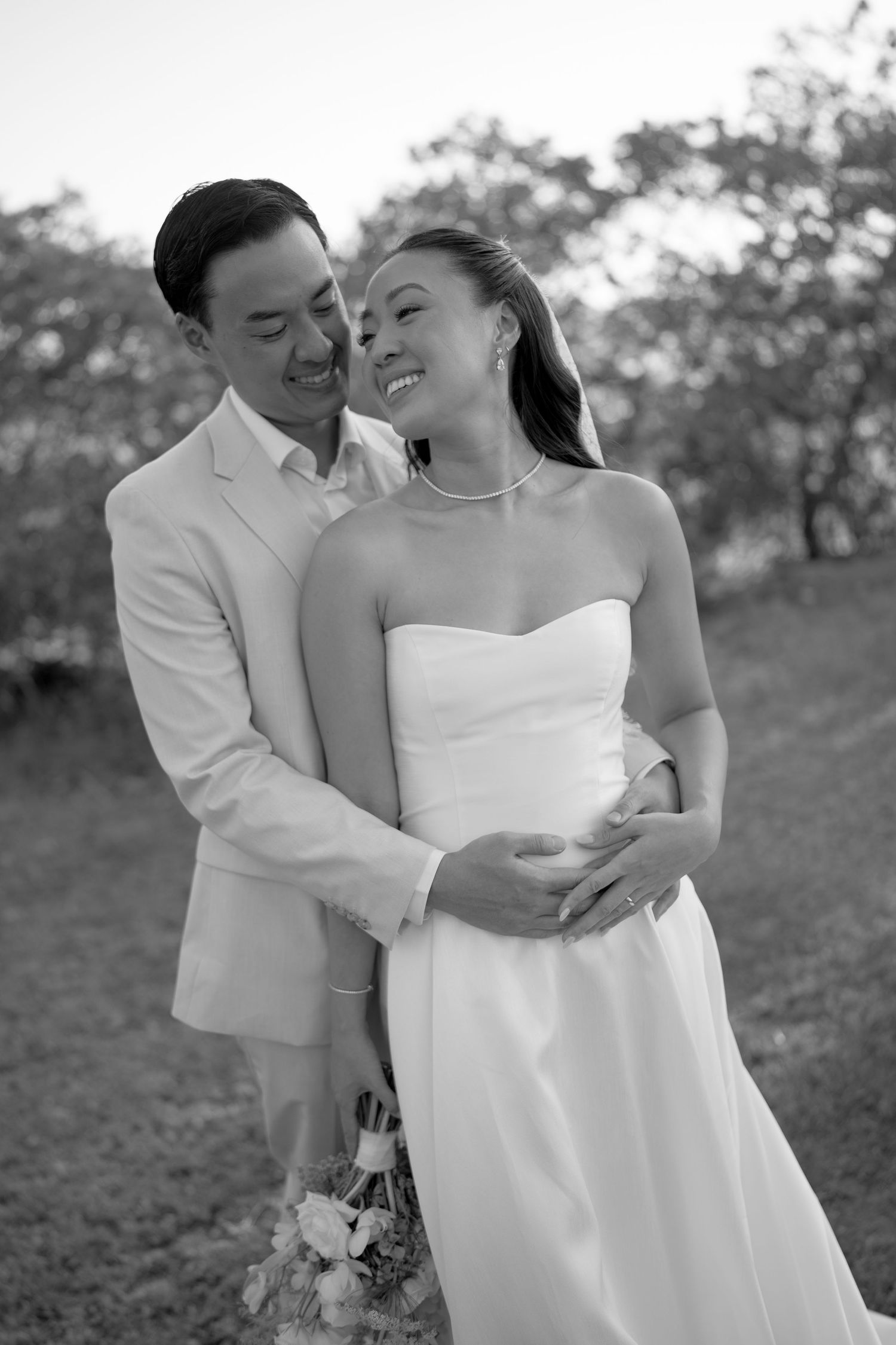 A romantic black and white wedding photo series showing a couple embracing in a garden setting.