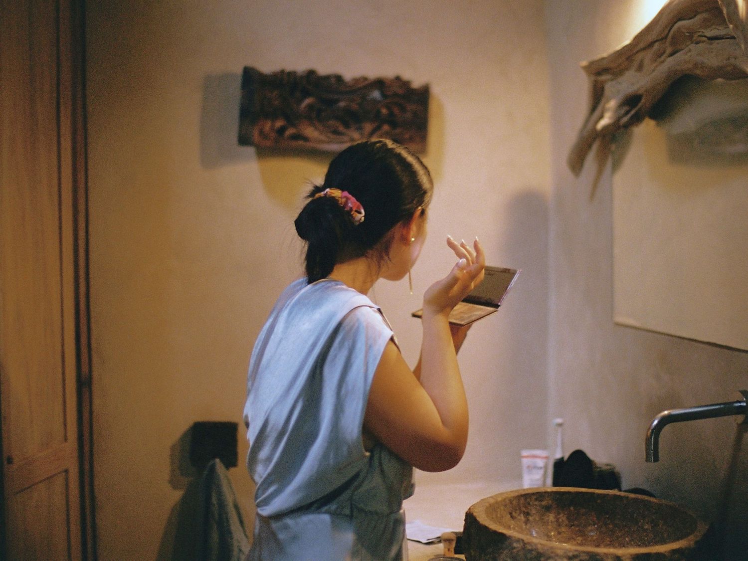 A candid moment captured in a rustic bathroom interior with warm lighting.