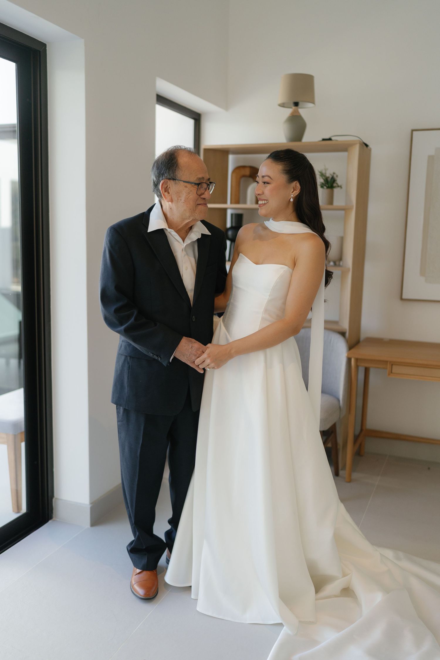 Emotional pre-wedding moments captured in a bright indoor setting with minimal decor.