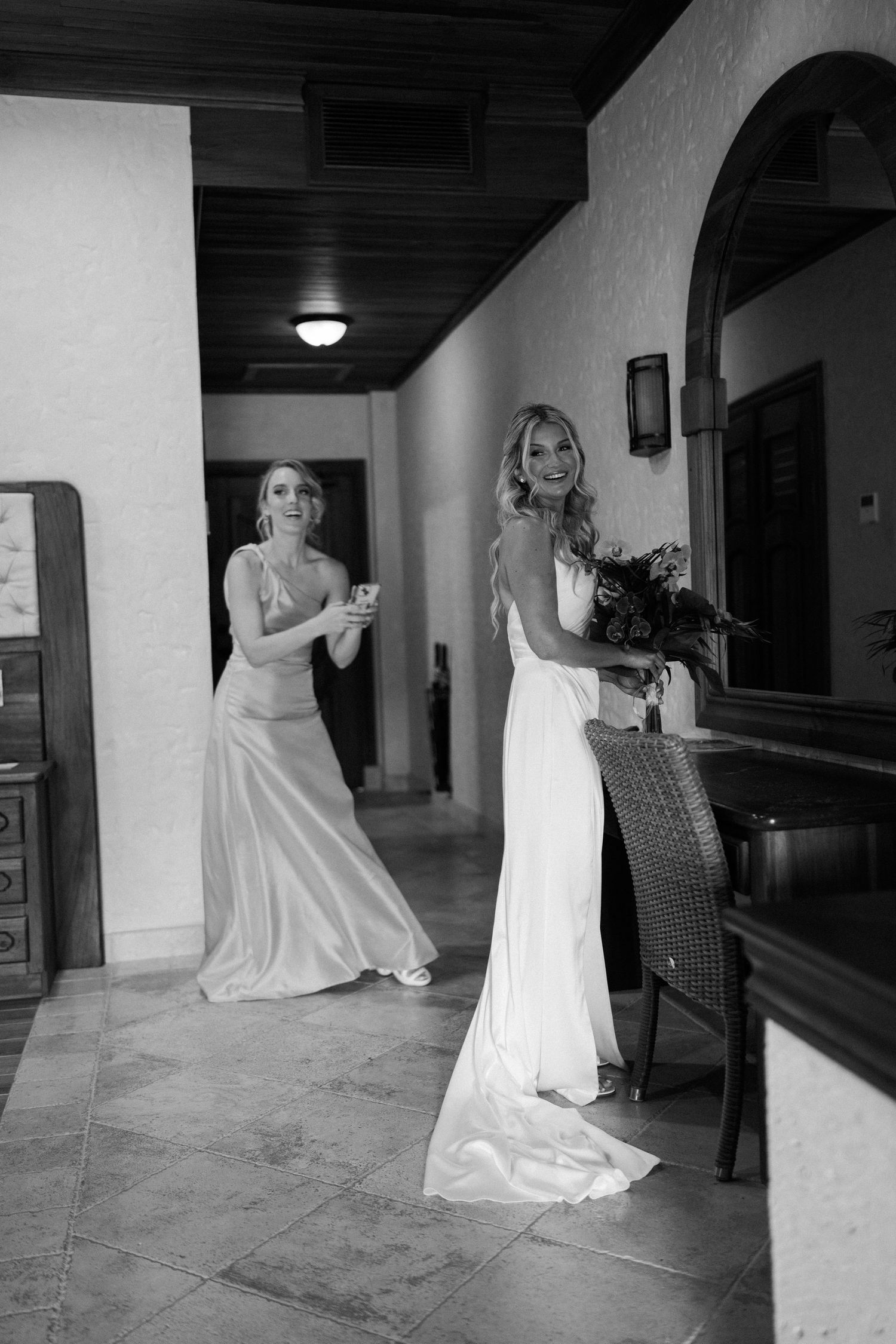 Artistic black and white series of bride in flowing dress posing in hallway.