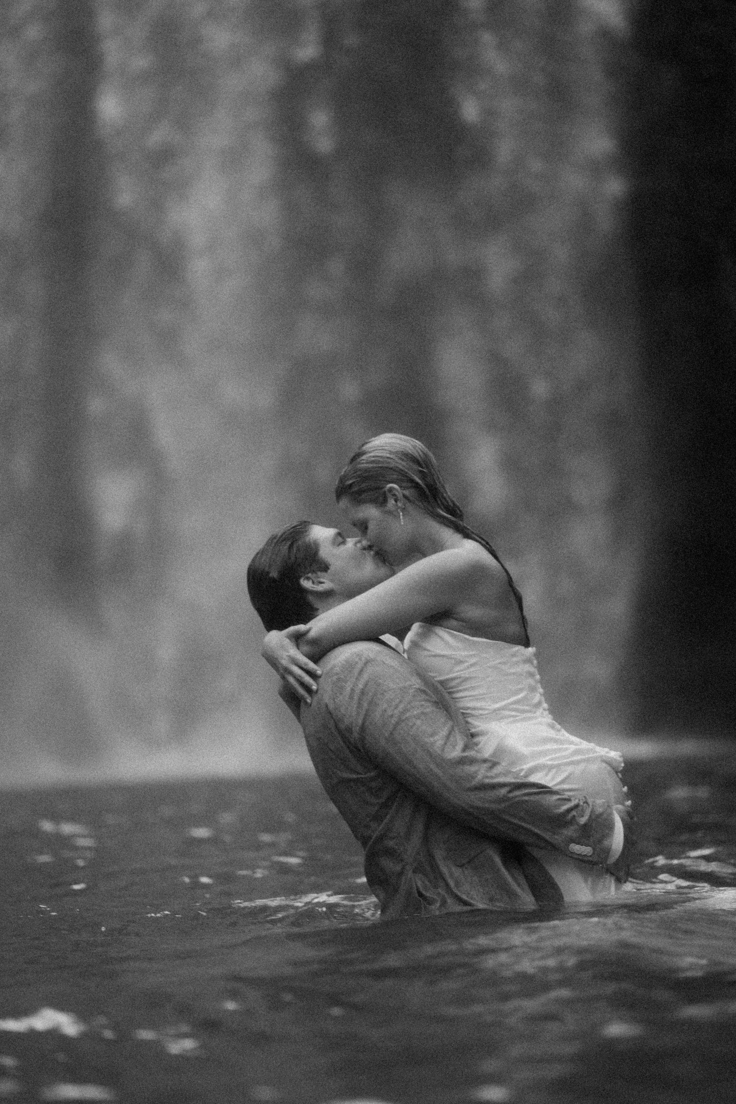A romantic couple shares an intimate moment in the misty waters.