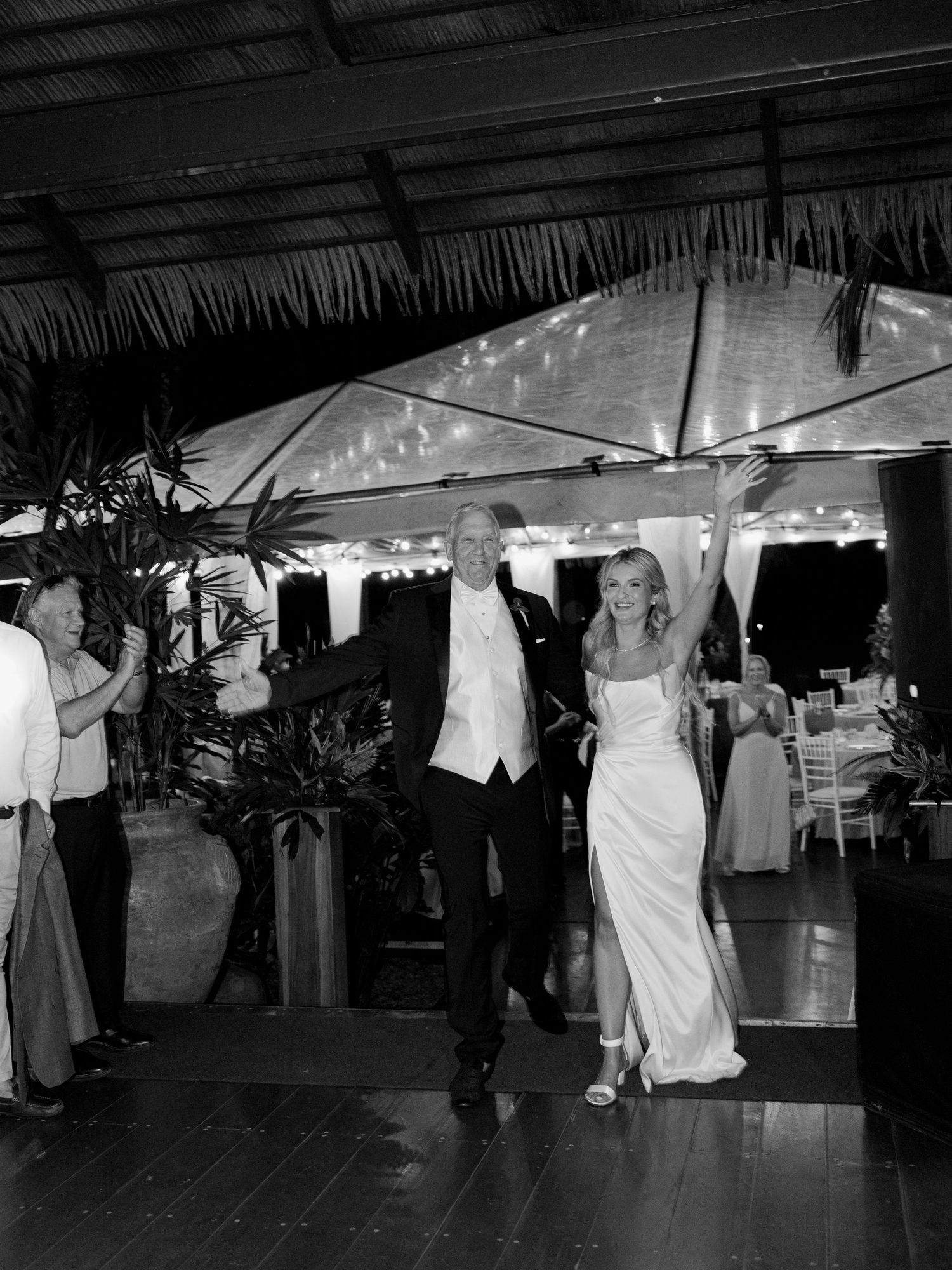 Wedding reception dance floor with guests dancing under covered outdoor venue.