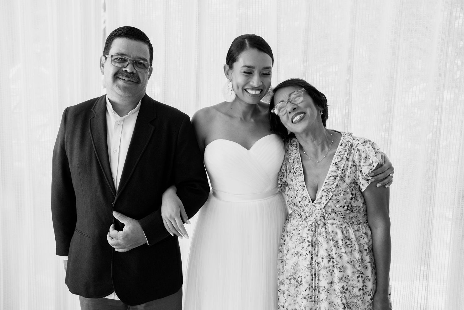 Wedding party members sharing joyful moments in black and white photography.
