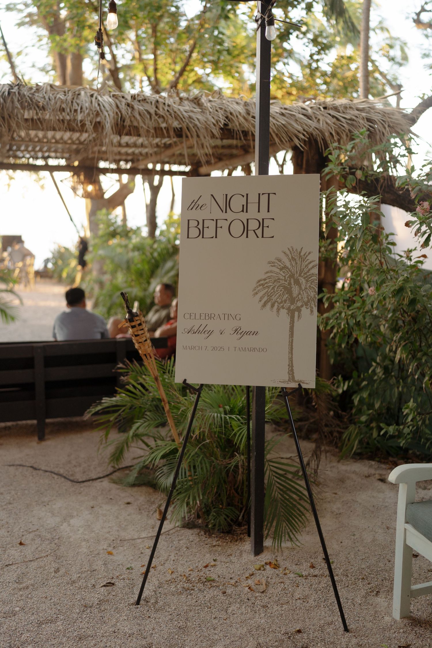 Wedding welcome signs displayed on easels at a tropical beach venue.