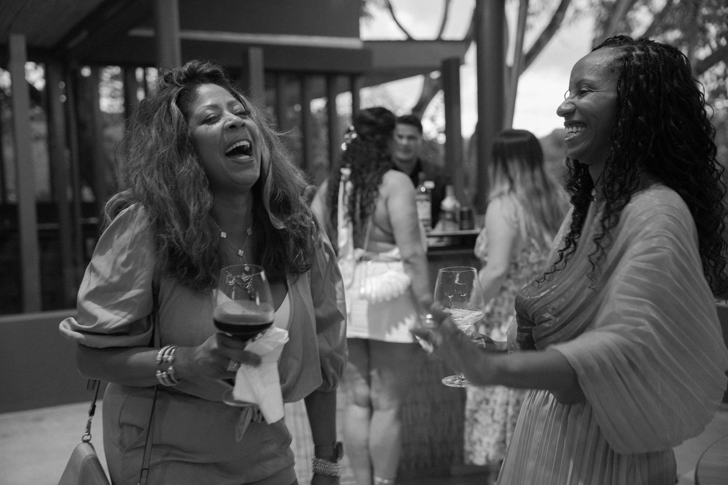 Black and white candid photo of wedding guests laughing and celebrating together.