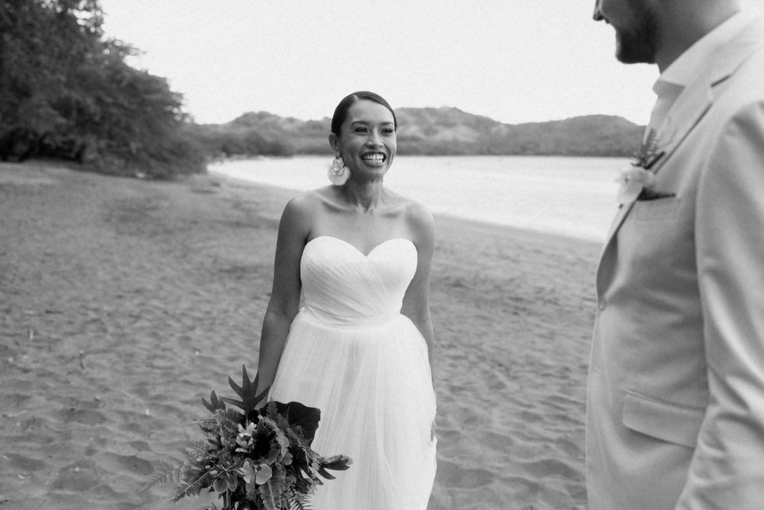 Romantic beachside wedding portraits with mountains in the background.