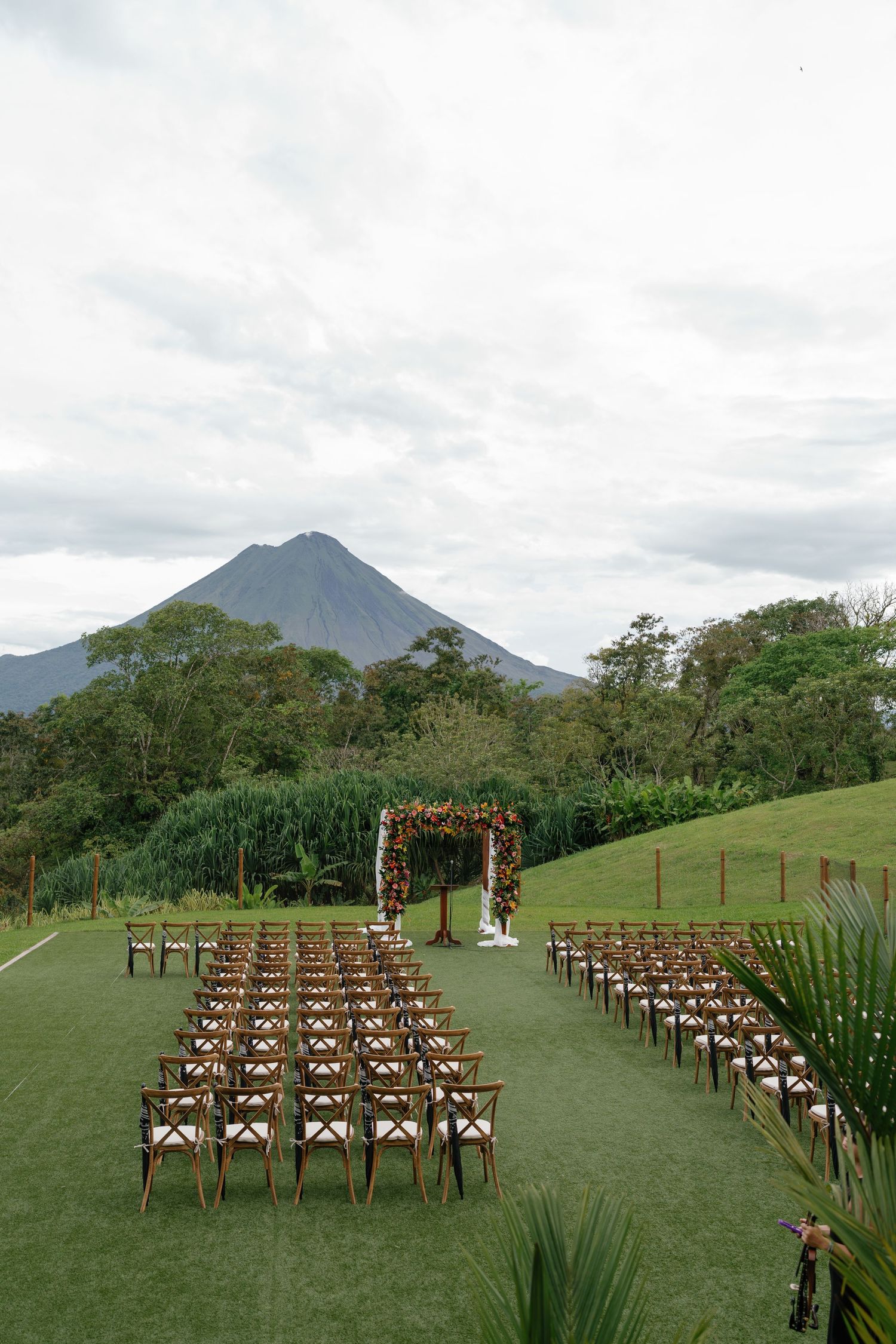 Outdoor wedding ceremony setup with wooden chairs facing a mountain vista.