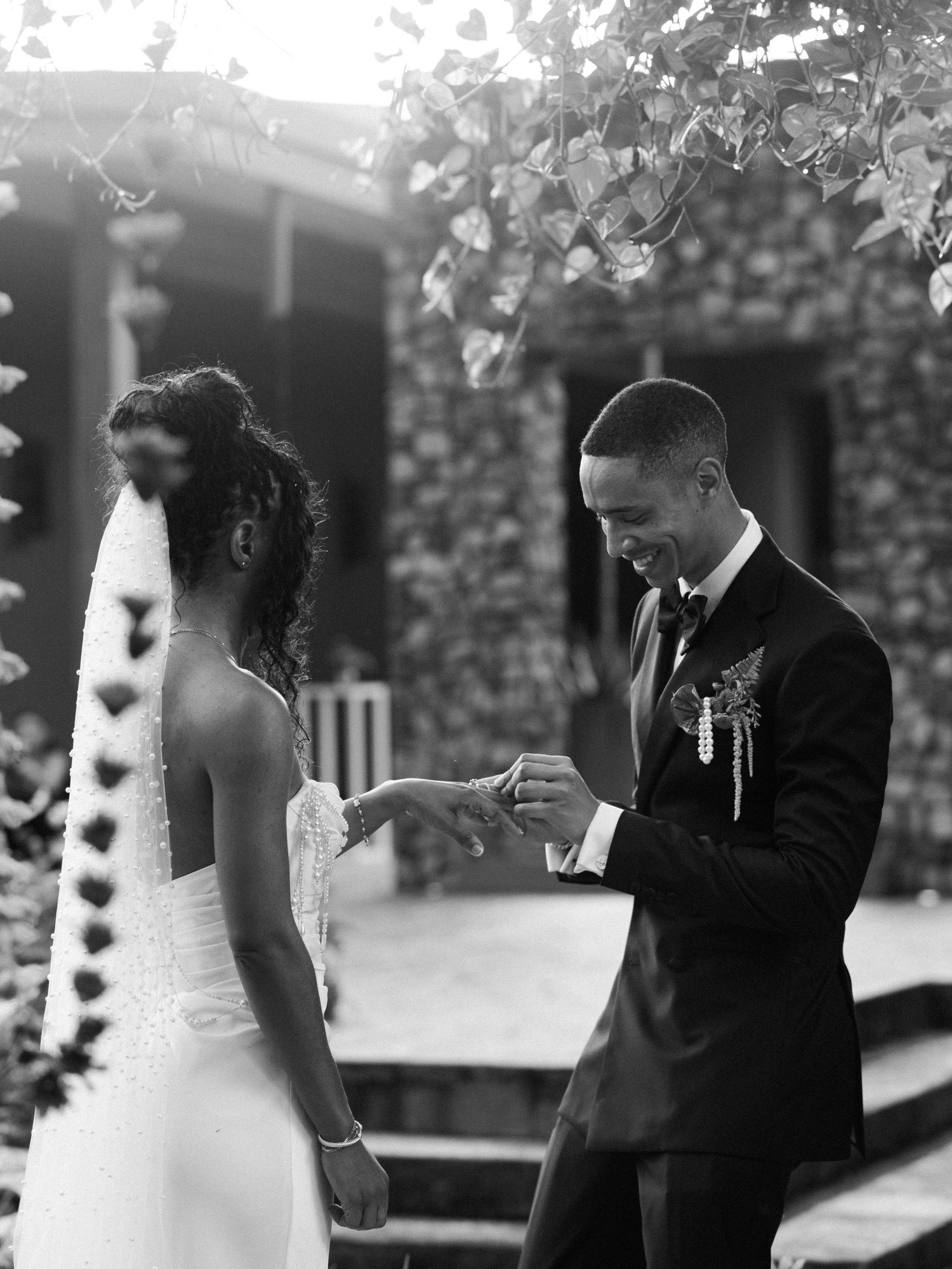 Black and white wedding photography showing an intimate moment in an outdoor garden setting.