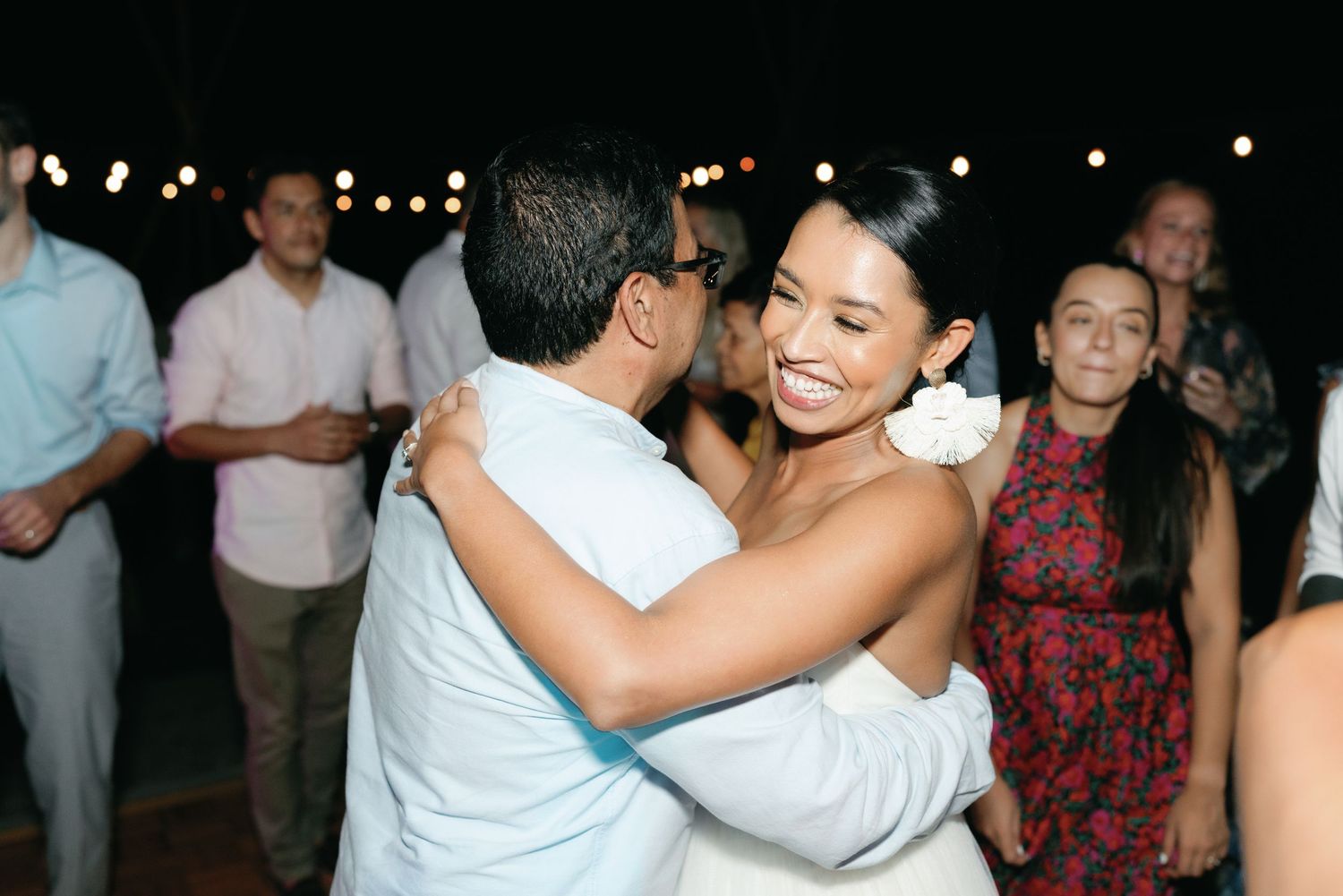Wedding guests dancing and celebrating during evening reception.