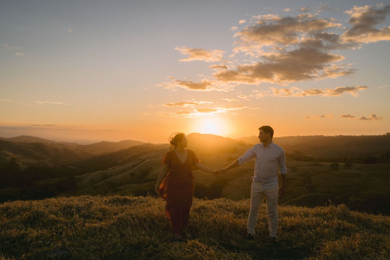 People enjoy a stunning California sunset over rolling golden hills.