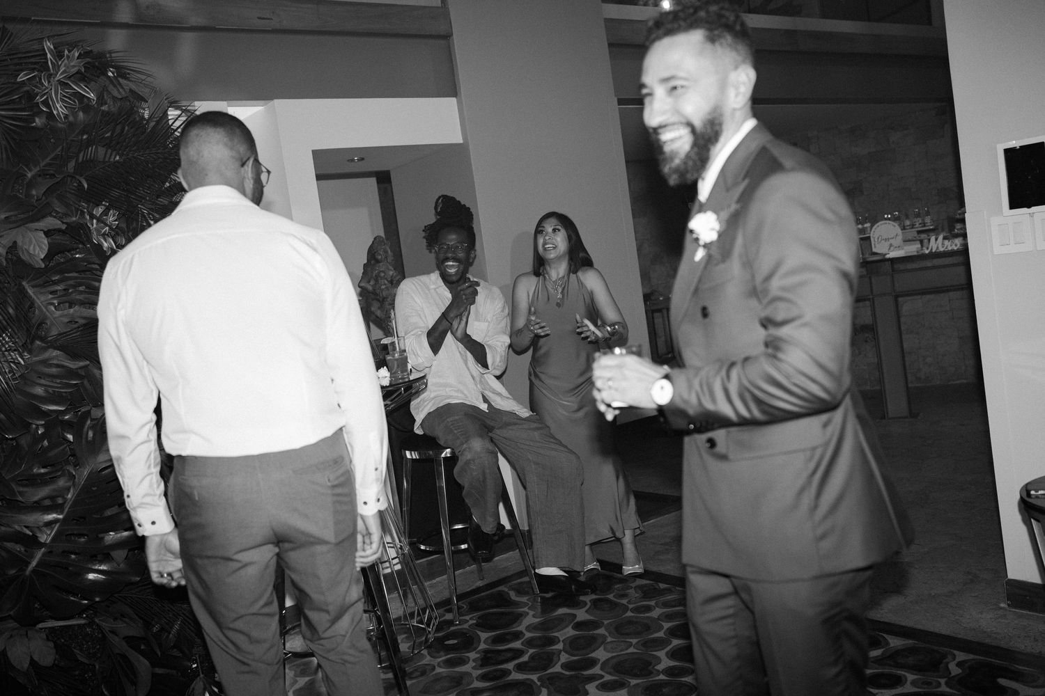 Black and white photos of people dancing at an indoor celebration.