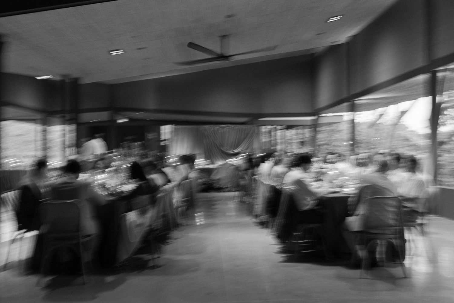 Panoramic view of a wedding reception hall with tables and chairs set for dining.