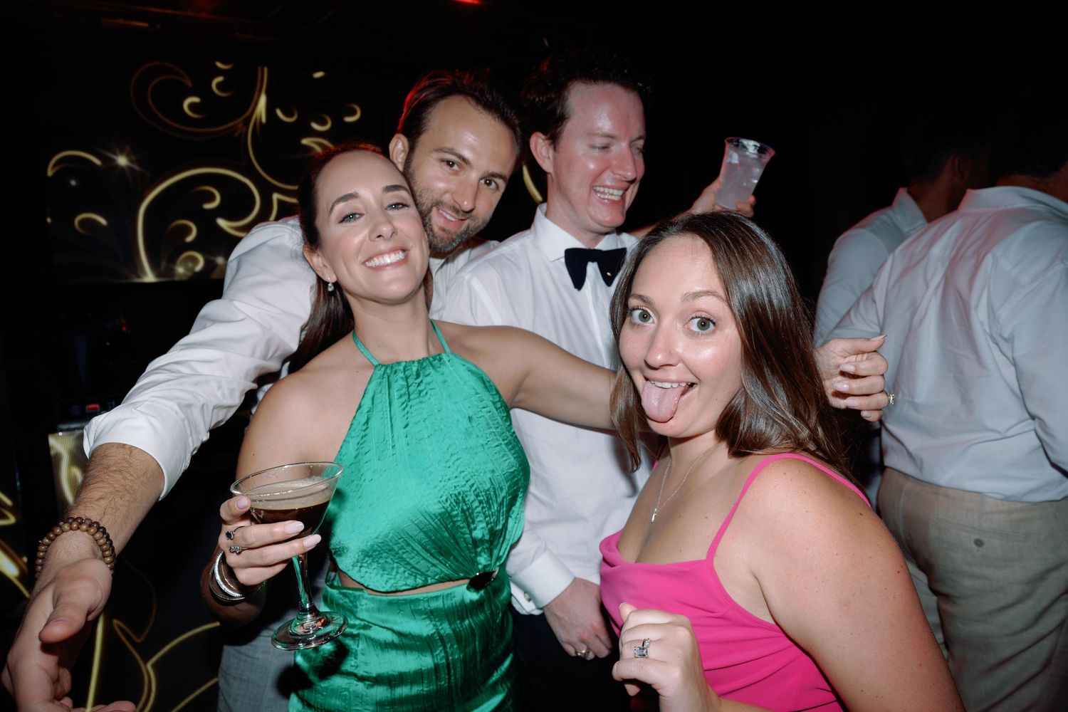 Wedding guests dancing and celebrating at a reception in colorful attire.