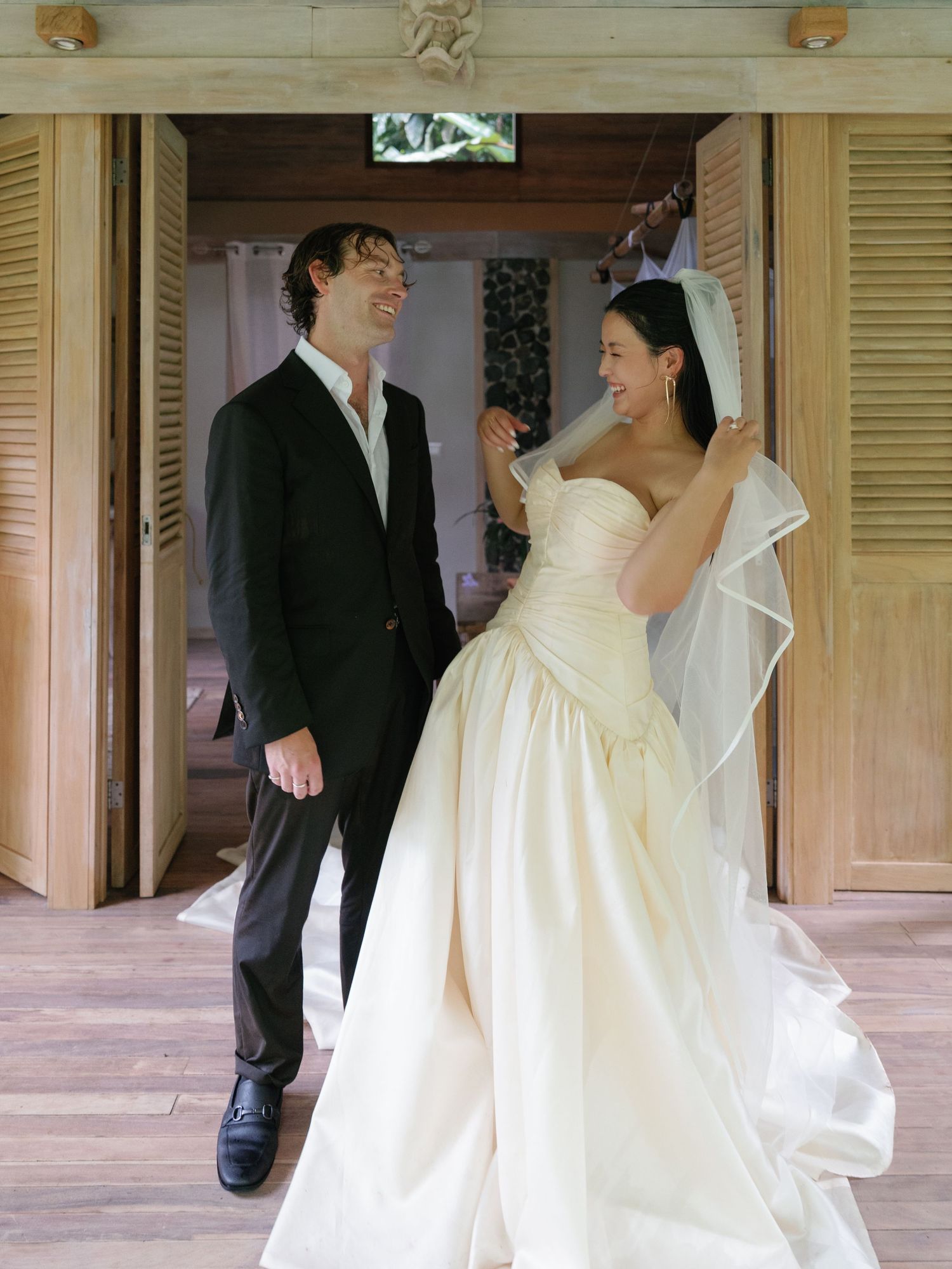 Wedding photos captured on a covered porch with wooden shutters and natural lighting.