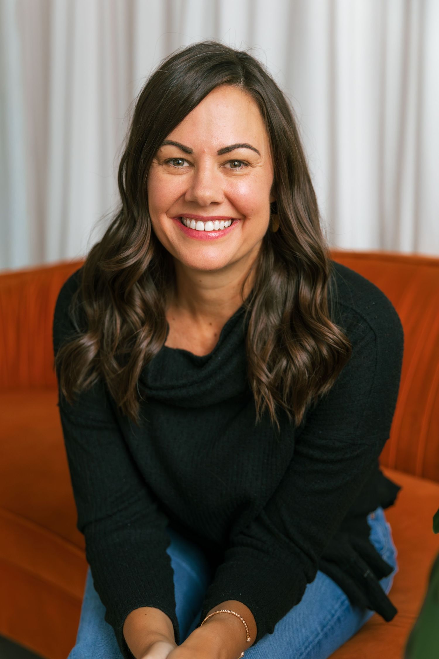 Casual lifestyle portraits showing genuine laughter and relaxed poses on couch.