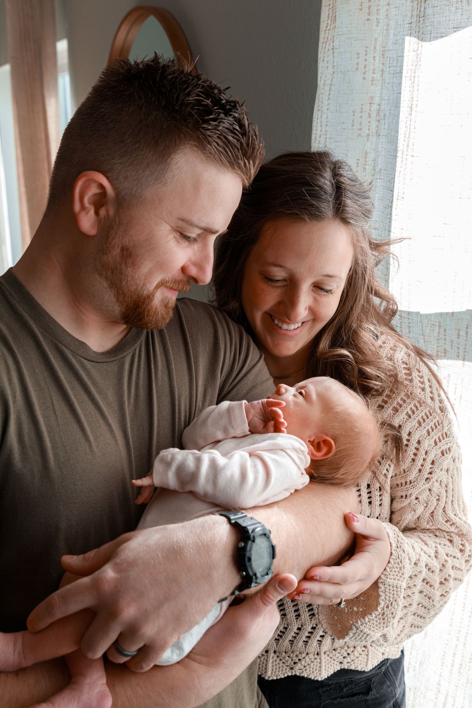 Tender moment with newborn baby in a cozy indoor setting.