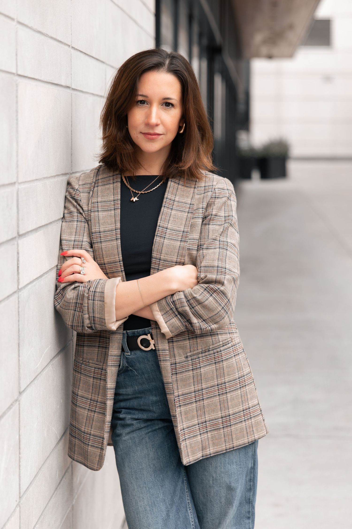 Professional fashion photo collage showing plaid blazer styled with dark top and jeans against white wall backdrop.